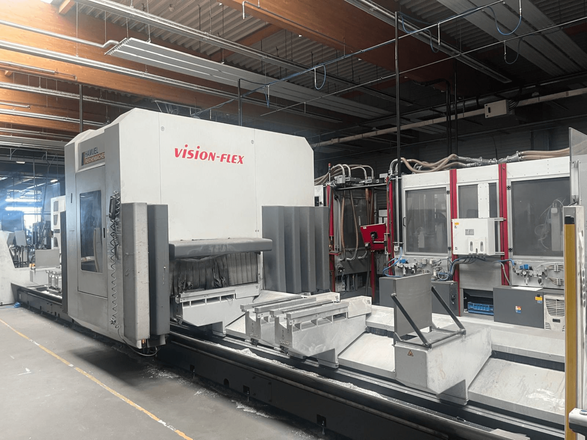 Verticaal bewerkingscentrum, Hamuel Reichenbacher Vision Flex, zijaanzicht met weergave van het werkgebied en de bedieningselementen in een industriële omgeving.