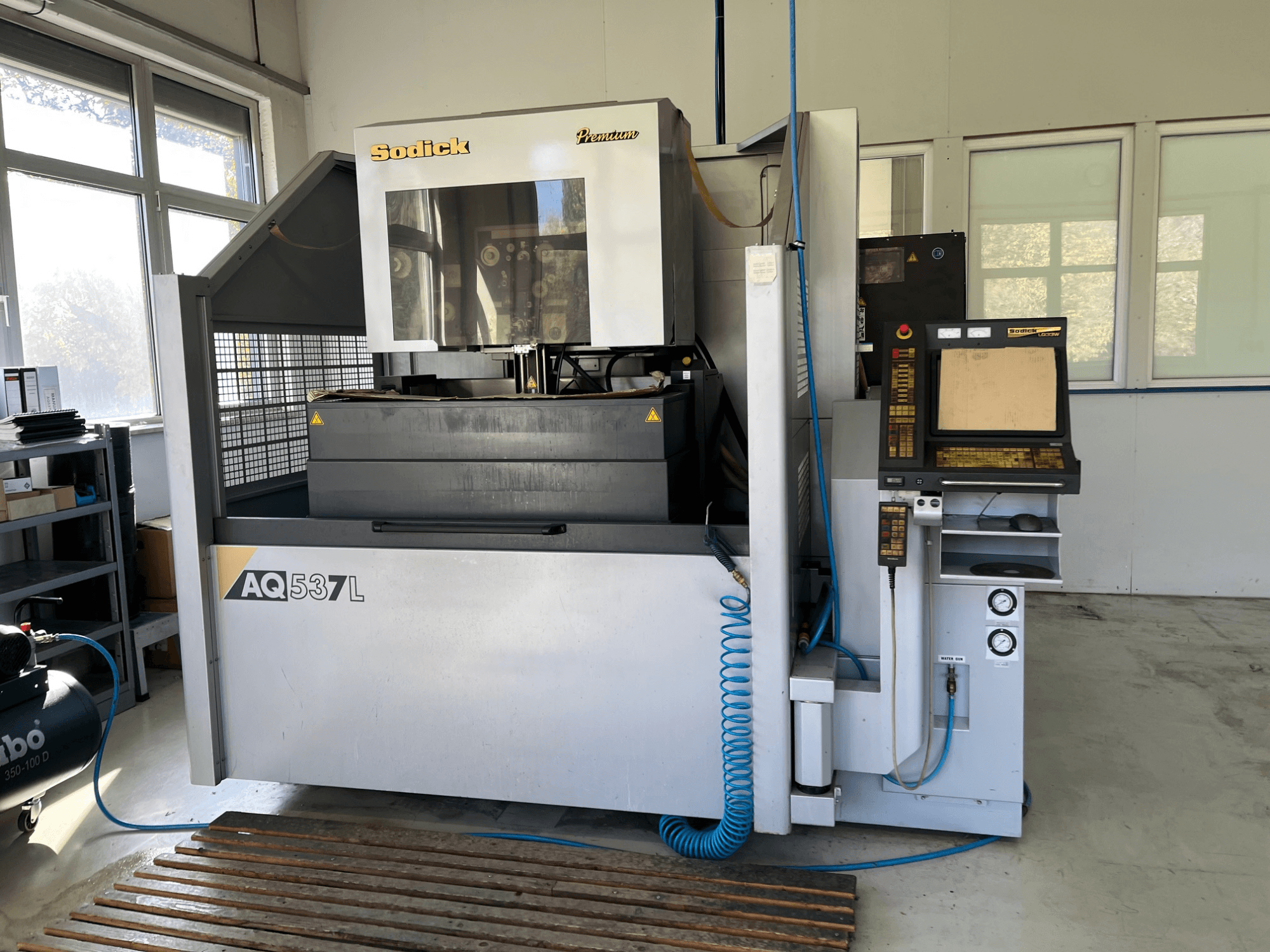 Sodick AQ537L elektrische ontladingsmachine (EDM) in vooraanzicht, met bedieningspaneel, waterkoelleidingen en werkruimte.