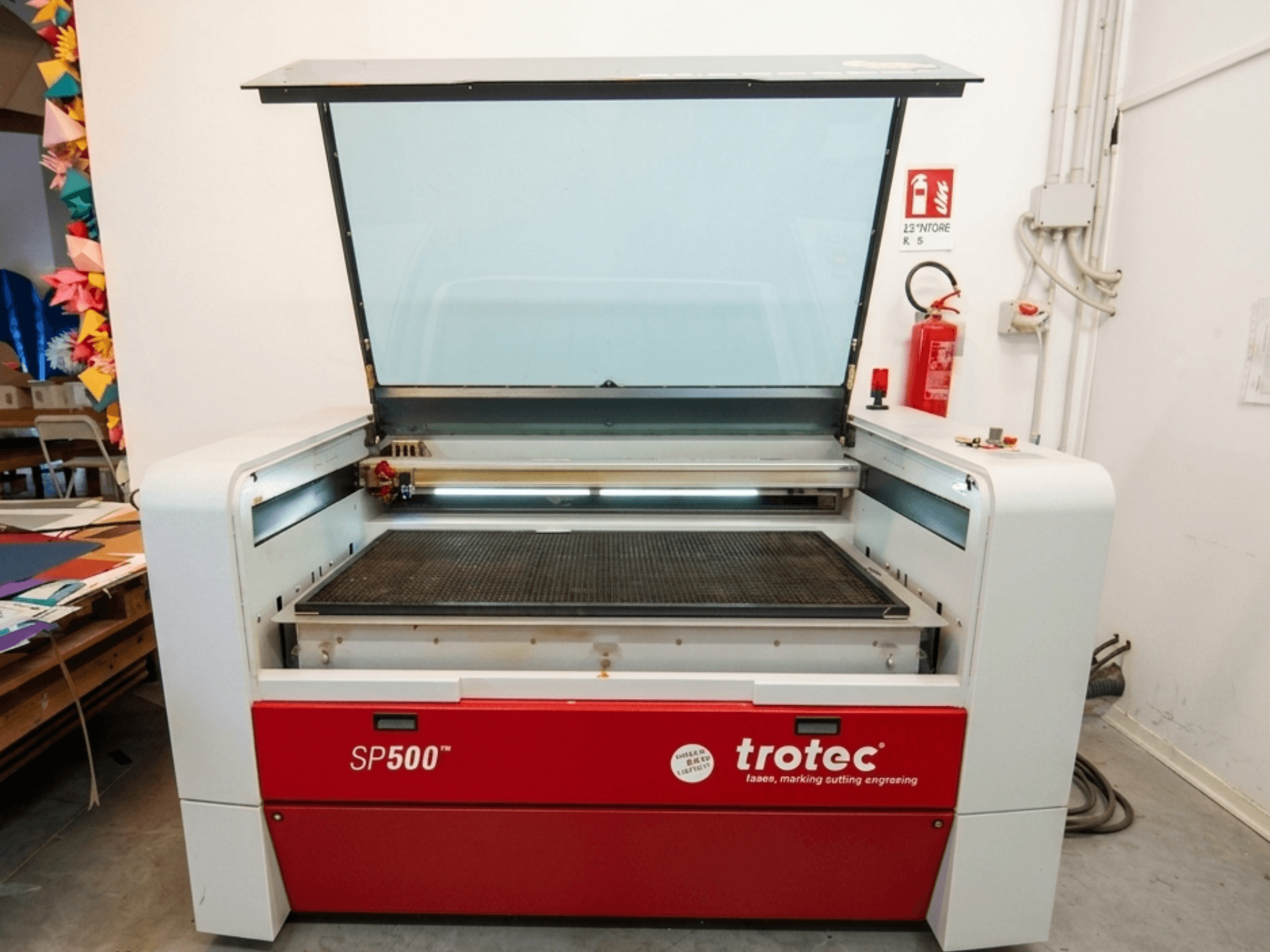 Trotec SP500 C200 lasergraveermachine in vooraanzicht, met een geopend deksel dat het werkgebied en de bedieningselementen toont.