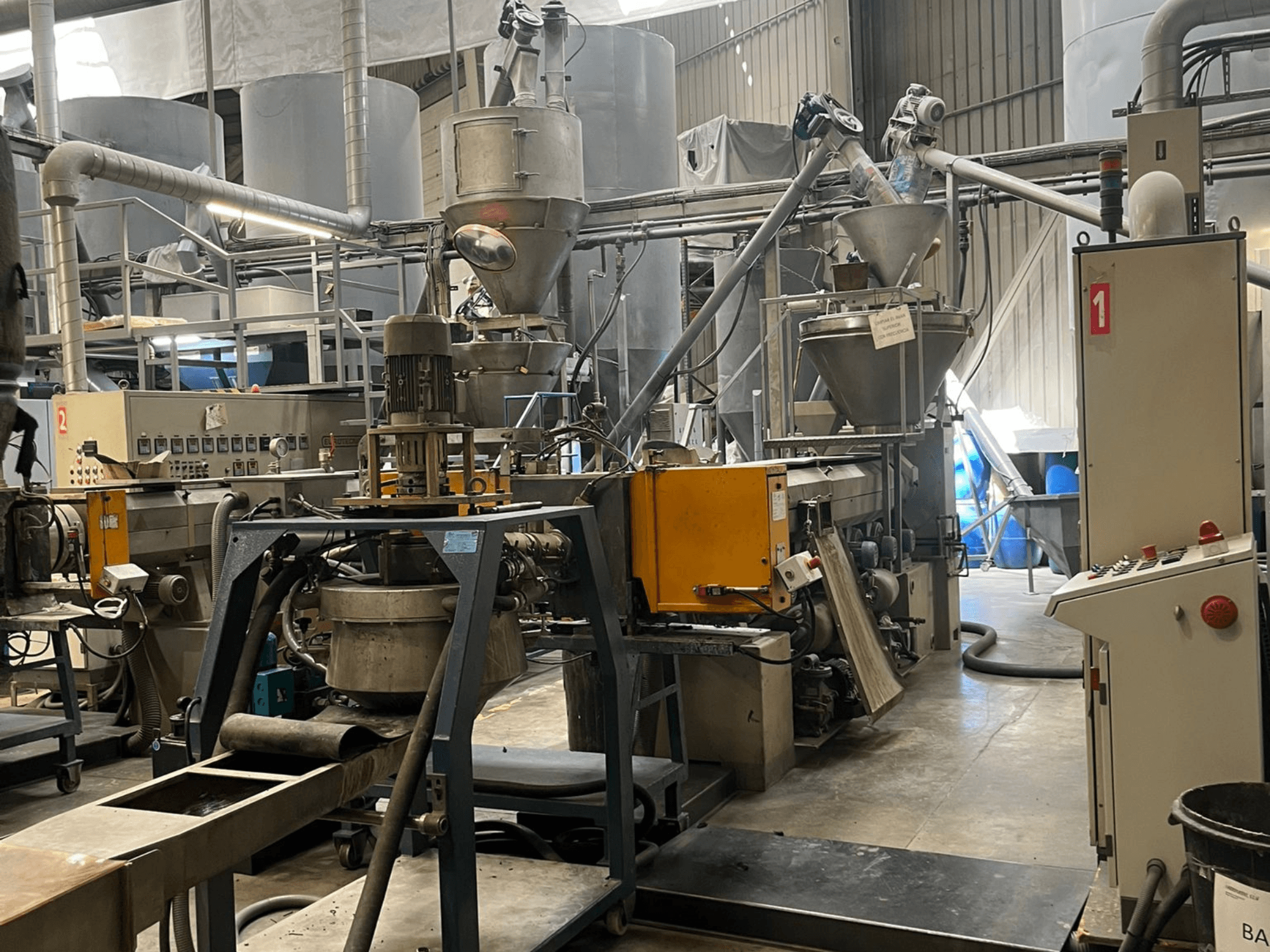 EUROTECNO E12535D-enkelassige extruder in een fabrieksomgeving, voorzien van verwerkingsonderdelen, trechters en bedieningspaneel.