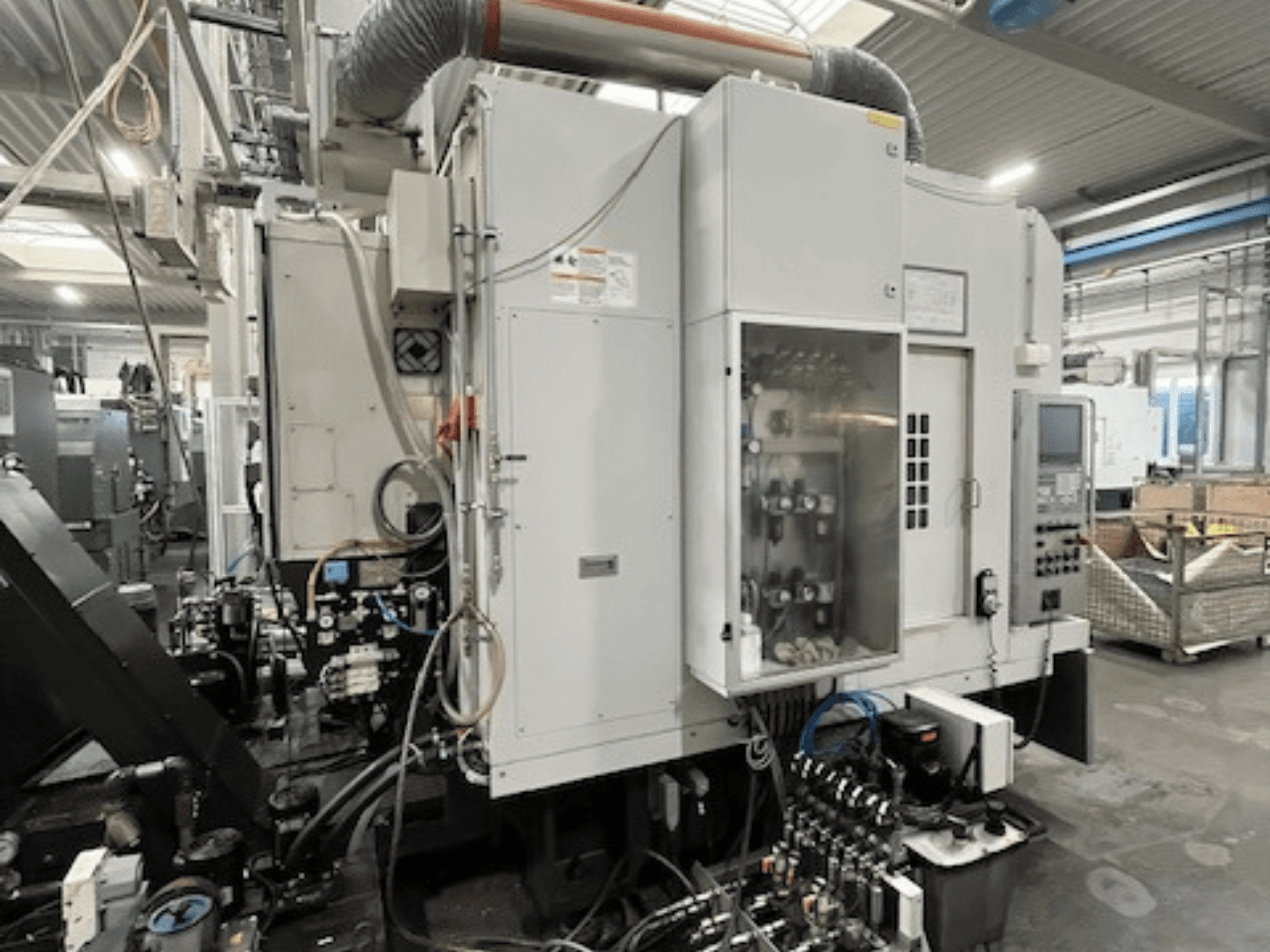 Zijaanzicht van industriële machine met bedieningspaneel en hydraulische componenten, met merk- en modeldetails.