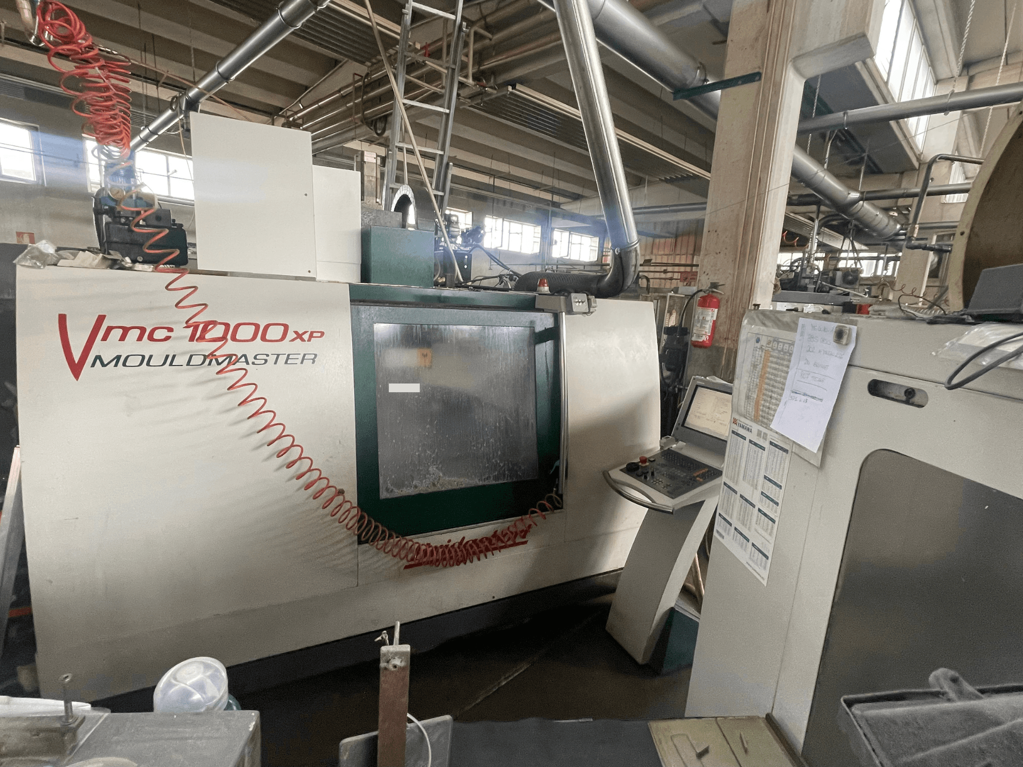 Verticaal bewerkingscentrum Bridgeport VMC 1000, vooraanzicht, met weergave van het bedieningspaneel en machineonderdelen in een industriële omgeving.