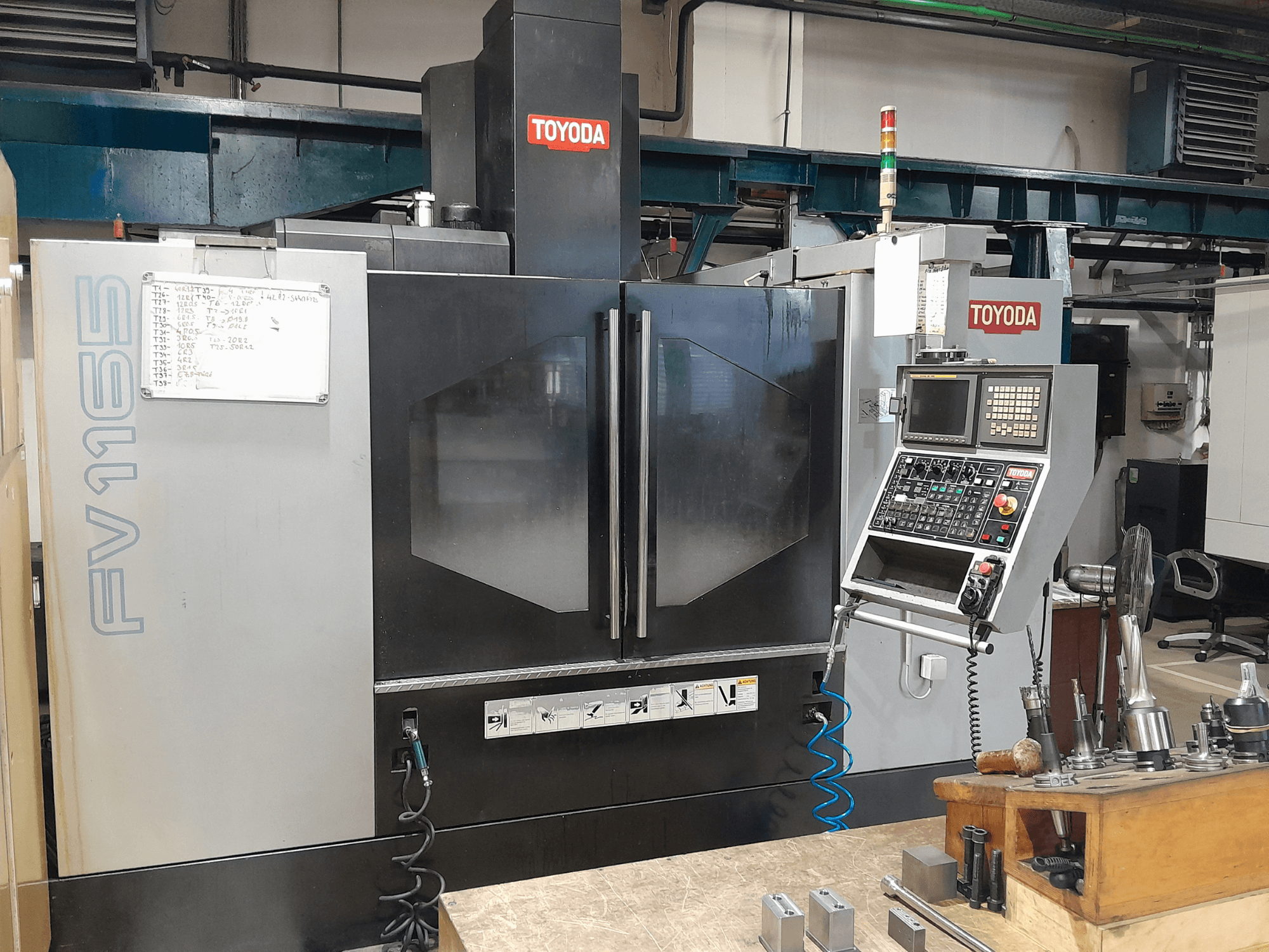 TOYODA FV 1165 verticaal bewerkingscentrum, vooraanzicht, met het bedieningspaneel en de bedrijfsindicatoren.