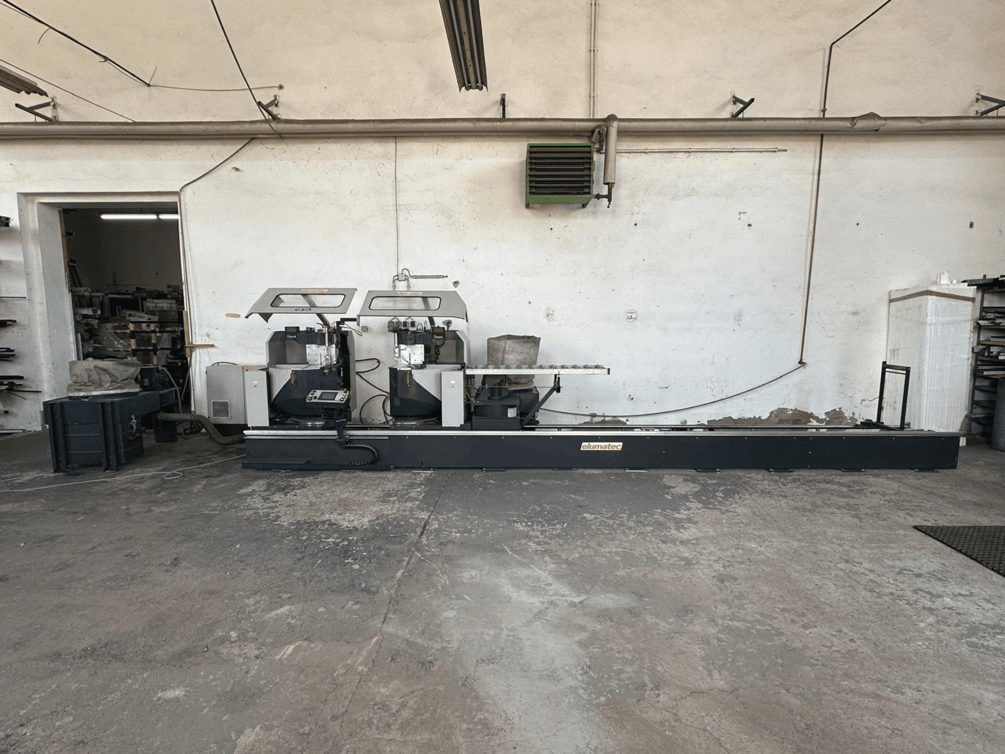 Elumatec DG 244 metaalcirkelzaag in een werkplaats, zijaanzicht met dubbele zagen en bedieningselementen op een stevige basis.