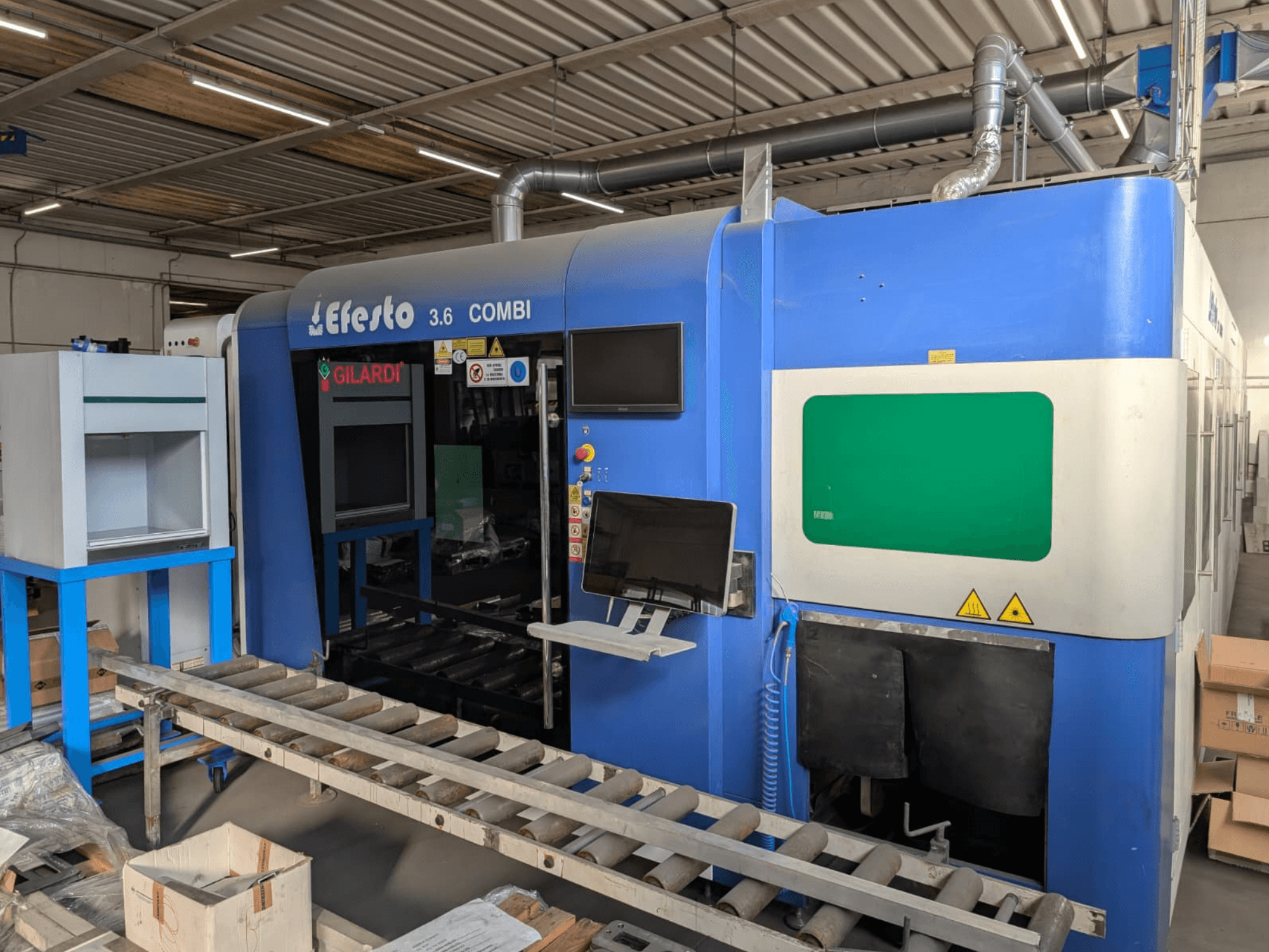 Fiberlasersnijmachine EFESTO 3.6 COMBI, zijaanzicht, met bedieningspaneel en veiligheidsindicatoren, uitgevoerd in een blauwe kleur.