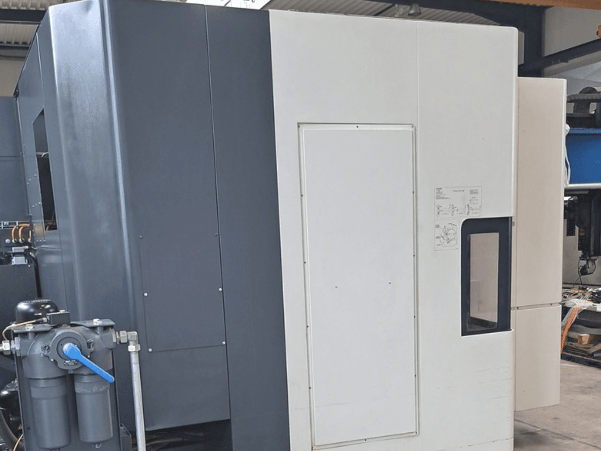 DMG MORI NHX5000 horizontaal bewerkingscentrum, zijaanzicht met bedieningspaneel en mechanische kenmerken.