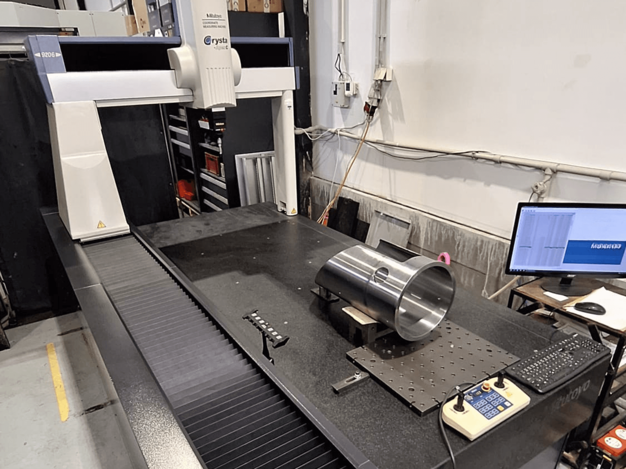 Mitutoyo Crysta-Apex C9206 CMM in vooraanzicht, meting van een cilindrisch metalen werkstuk op een zwart granieten oppervlakteplaat.