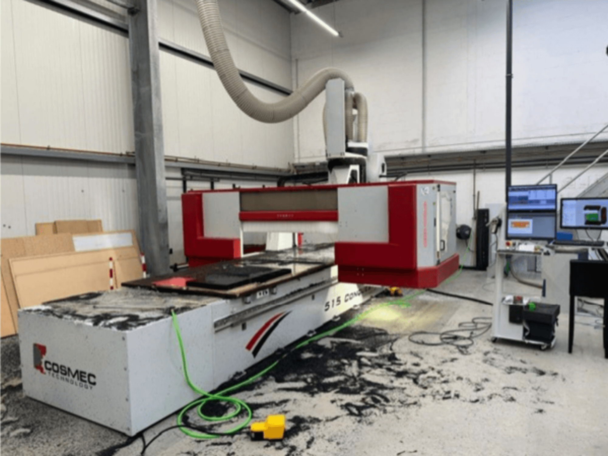 Cosmec 515 CNC machine in werkplaats met computerterminal, met vooraanzicht en stofverspreiding op het oppervlak.