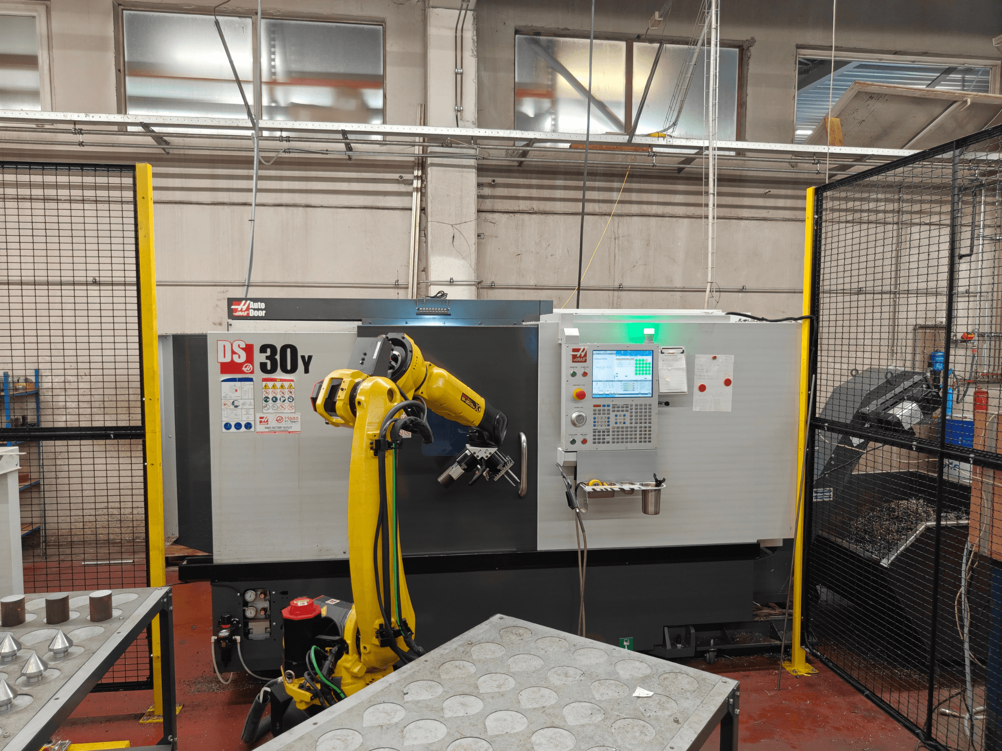HAAS DS30Y horizontale draaibank met robotarm, vooraanzicht, met het bedieningspaneel en de werkruimte.