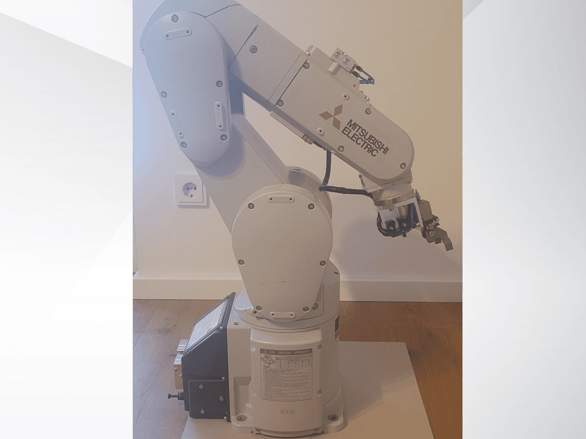 Mitsubishi Electric robotarm, zijaanzicht, met een grijper en een gedetailleerd bedieningspaneel op de basis voor bedieningsinstellingen.