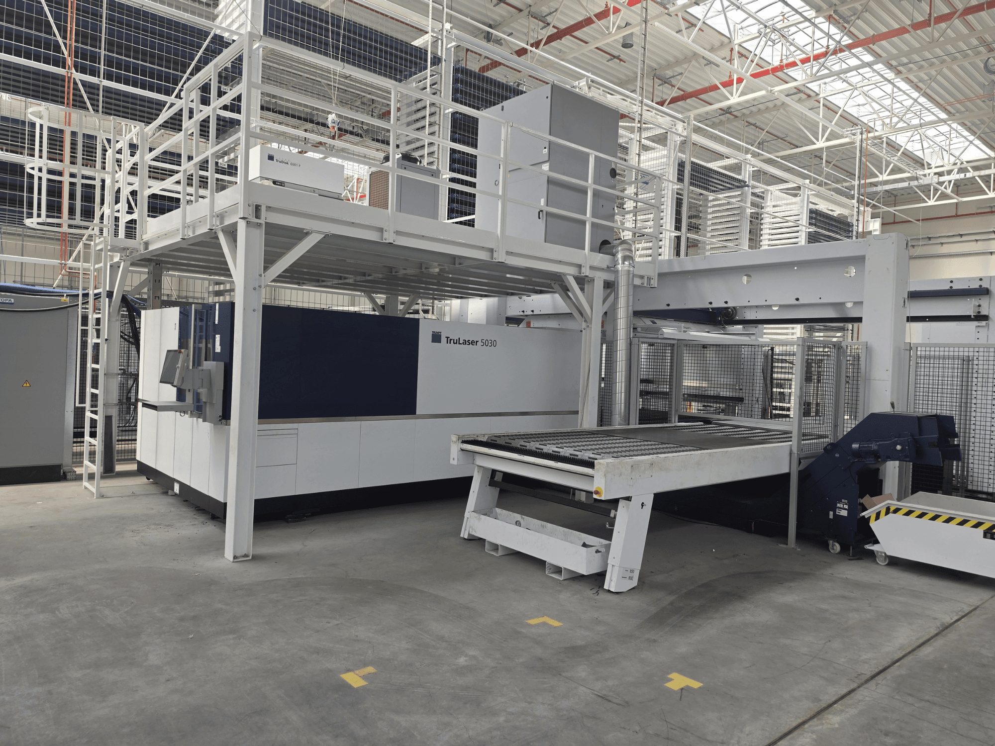 TRUMPF TruLaser 5030 fiber L76 FMC-machine in een werkplaats, vooraanzicht met weergave van het snijgebied en het laad- en losmechanisme.