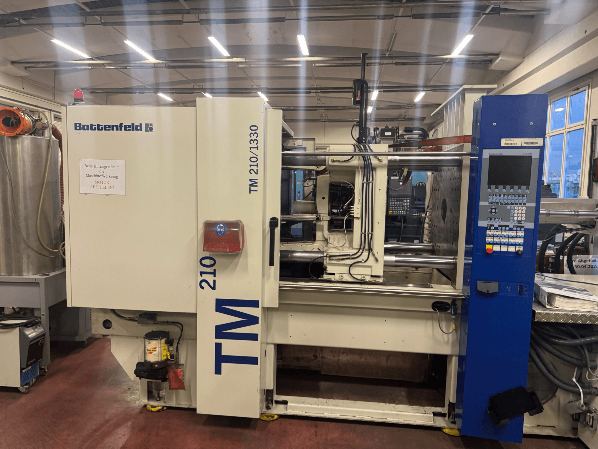 Battenfeld TM 210/1330 hydraulische spuitgietmachine, vooraanzicht, met bedieningspaneel en machineonderdelen.