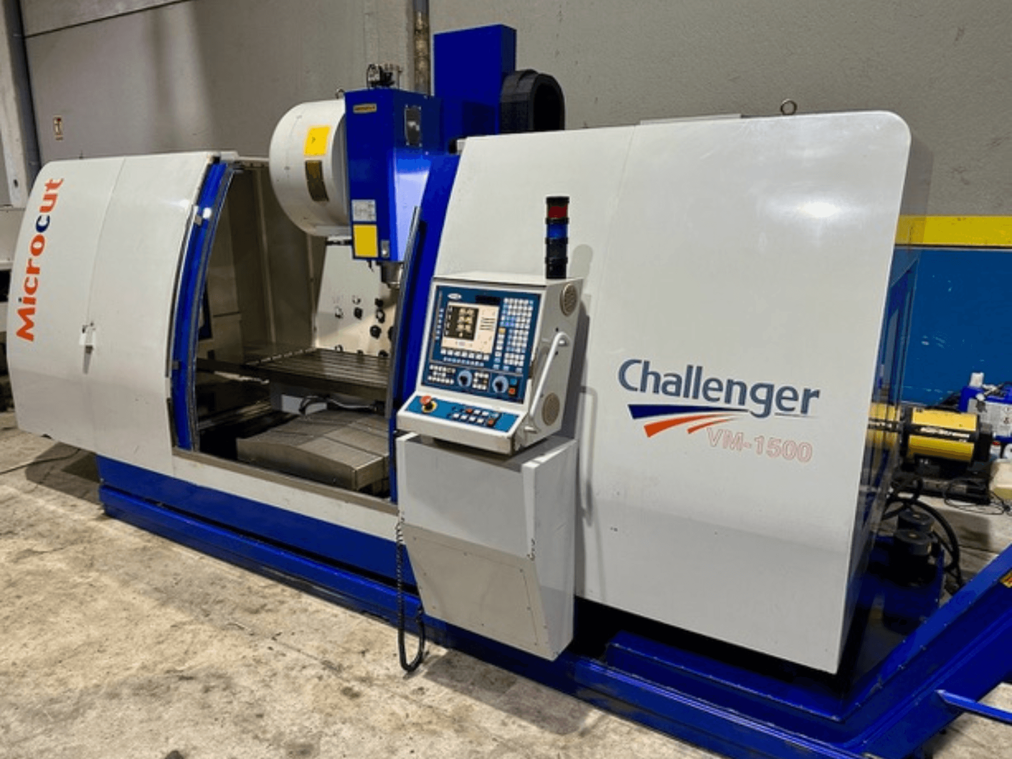 Microcut Challenger VM-1500 CNC machine, vooraanzicht, met bedieningspaneel, werkruimte en een blauwe basis.