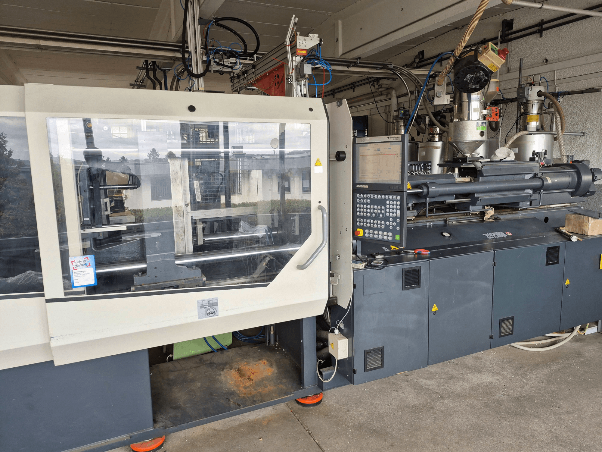 Hydraulische spuitgietmachine, SUMITOMO SHI DEMAG Systec 210/580-1450, vooraanzicht met bedieningspaneel en zichtbare onderdelen.