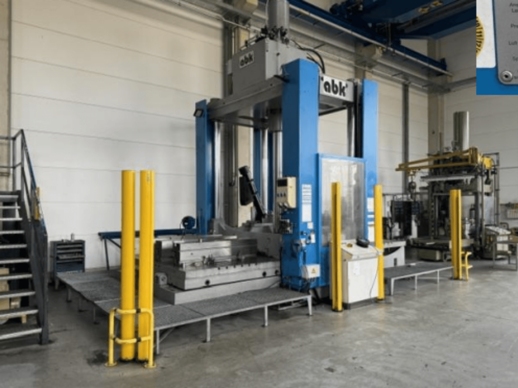 ABK abk-TP-20-250-bewerkingsmachine gezien vanaf de voorkant, met veiligheidsgele afschermingen en de omliggende bewerkingsapparatuur.