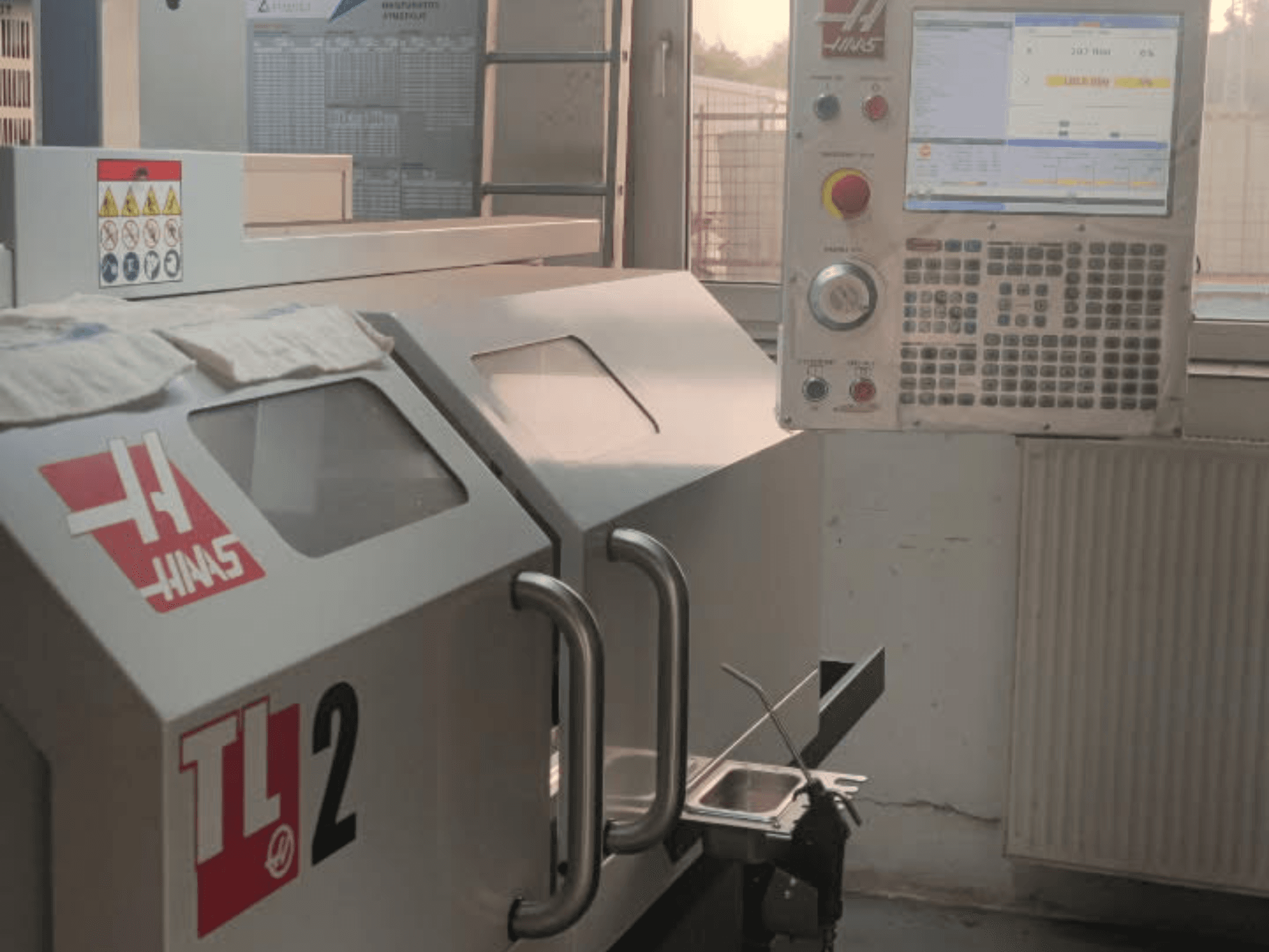 Vooraanzicht Haas TL-2 horizontale draaimachine, met bedieningspaneel, metalen behuizing en veiligheidsborden.