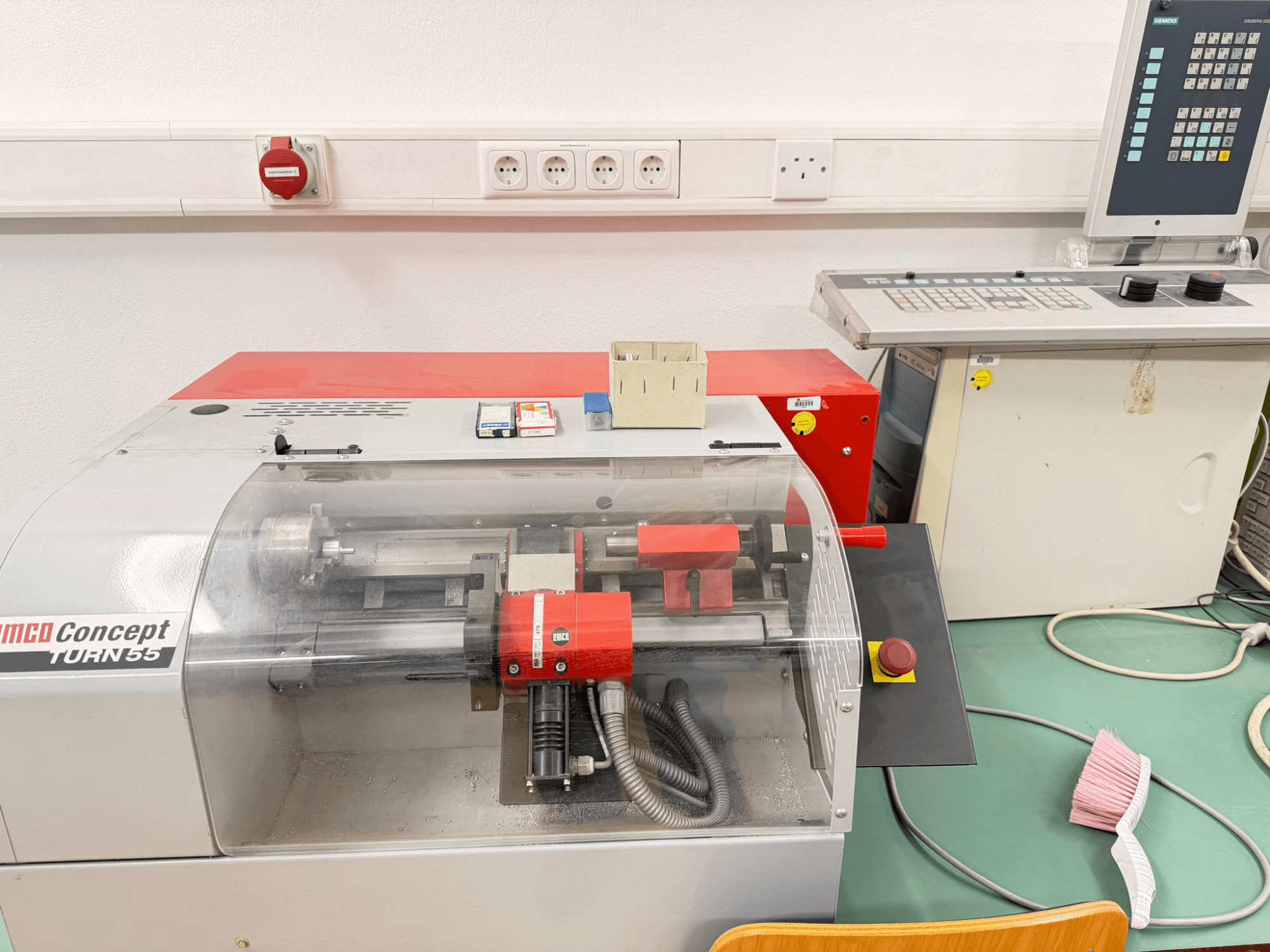 EMCO Concept Turn 55 horizontale draaimachine met rood en grijs exterieur, vooraanzicht met bedieningselementen en werkgebied.