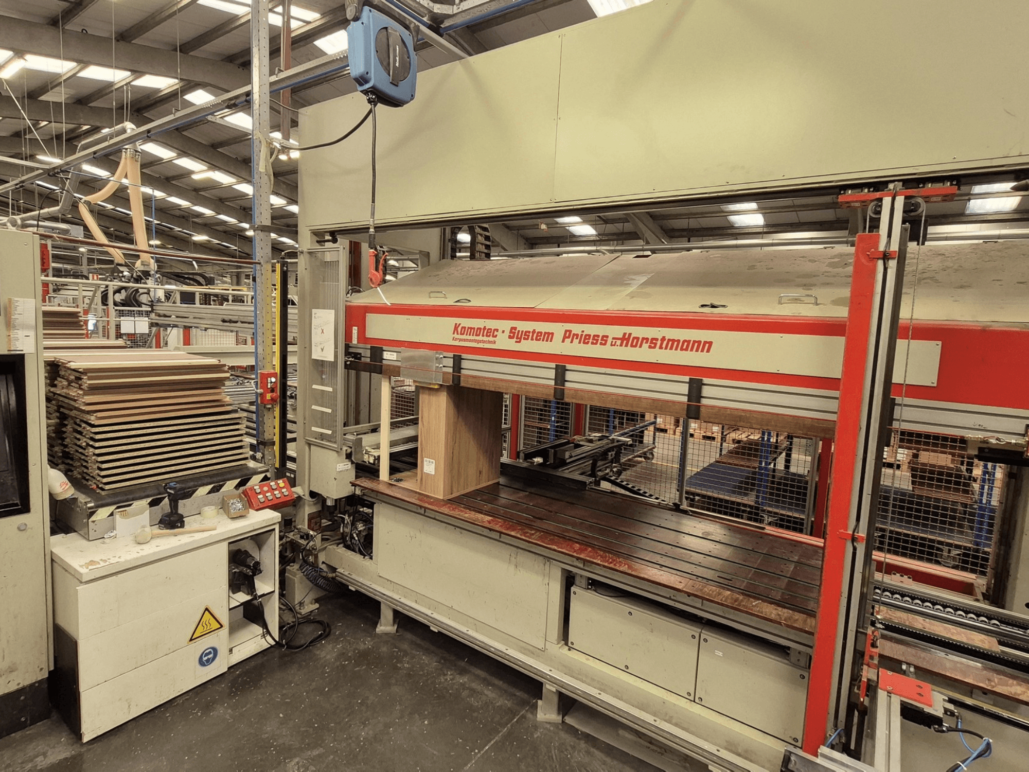 Fineerpers KP-5-CNC van PREISS U HORTSTMANN, vooraanzicht, met gestapelde fineervellen en bedieningspaneel.