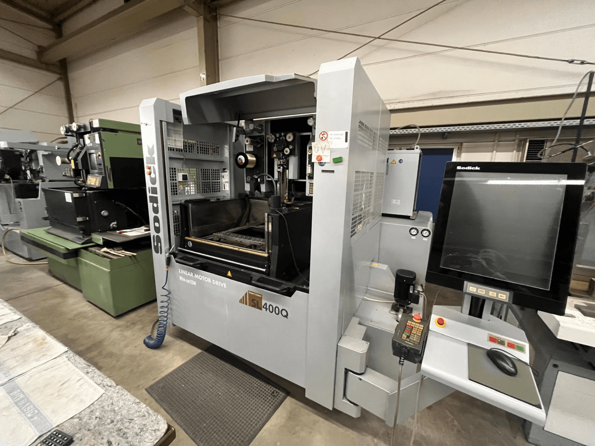 Sodick SL400Q CNC machine met lineaire aandrijving, vooraanzicht met digitaal bedieningspaneel en display in een werkplaats.