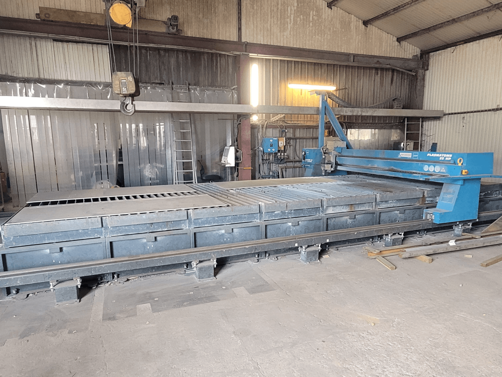 SAF Plasmatone 25Hp plasmasnijmachine, zijaanzicht, met het snijbed en operationele componenten in een industriële omgeving.