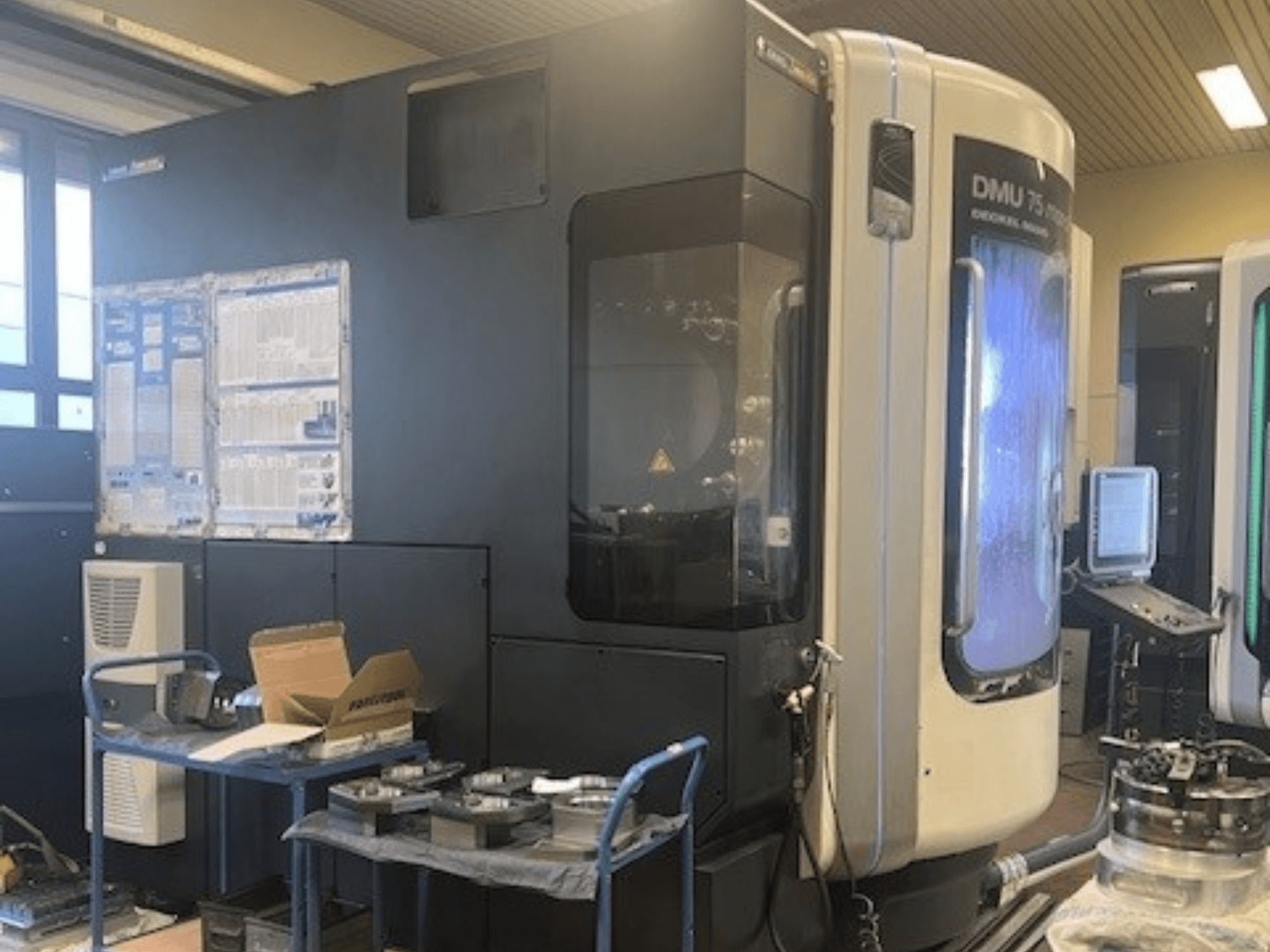 DMG Mori Seiki DMU 75 monoBlock universeel bewerkingscentrum, vooraanzicht, met het bedieningspaneel, koelsysteem en werkruimte.