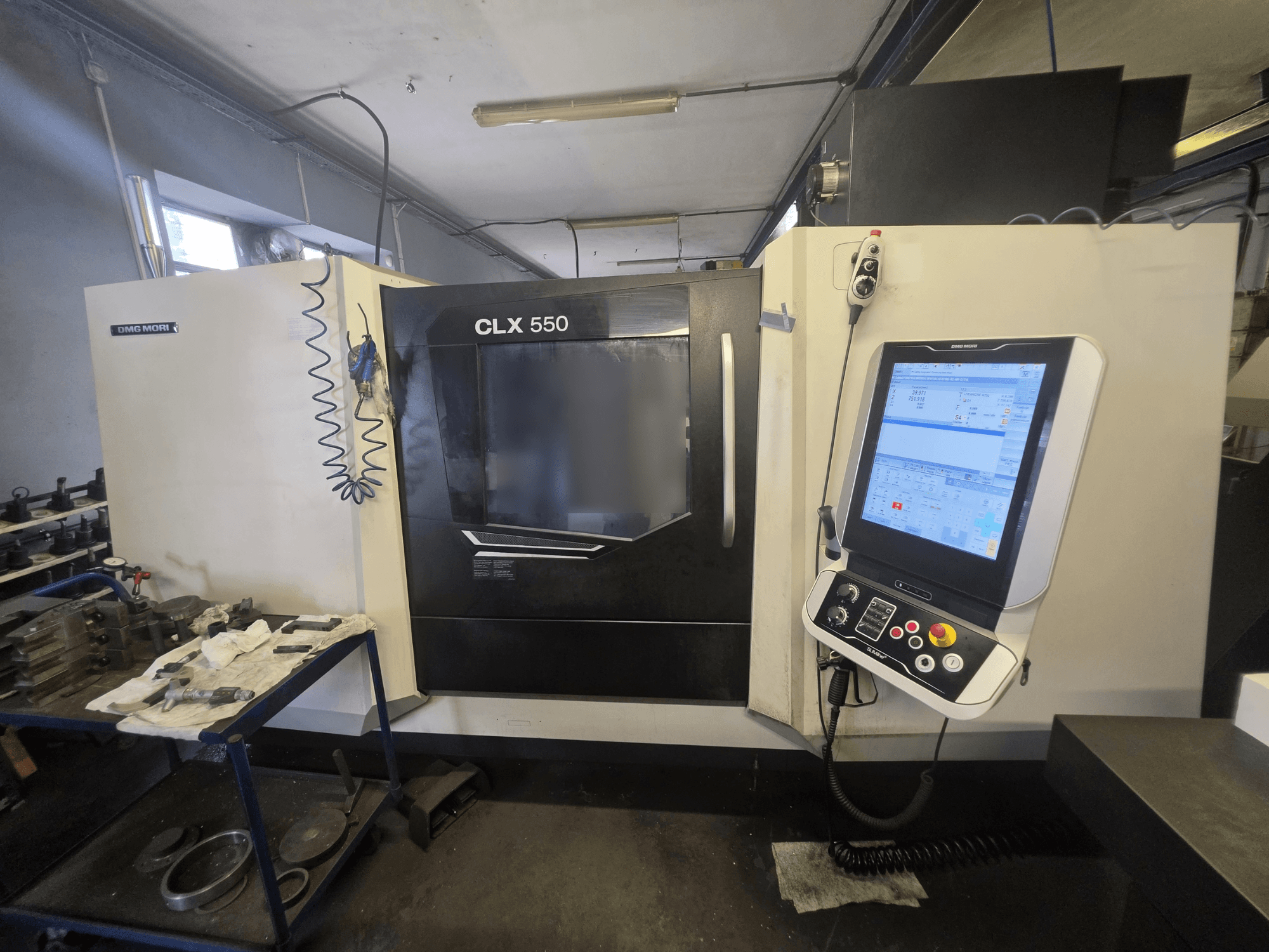 DMG MORI CLX 550 V3 horizontale draaimachine, vooraanzicht, met het bedieningspaneel en de werkruimte met gereedschappen.
