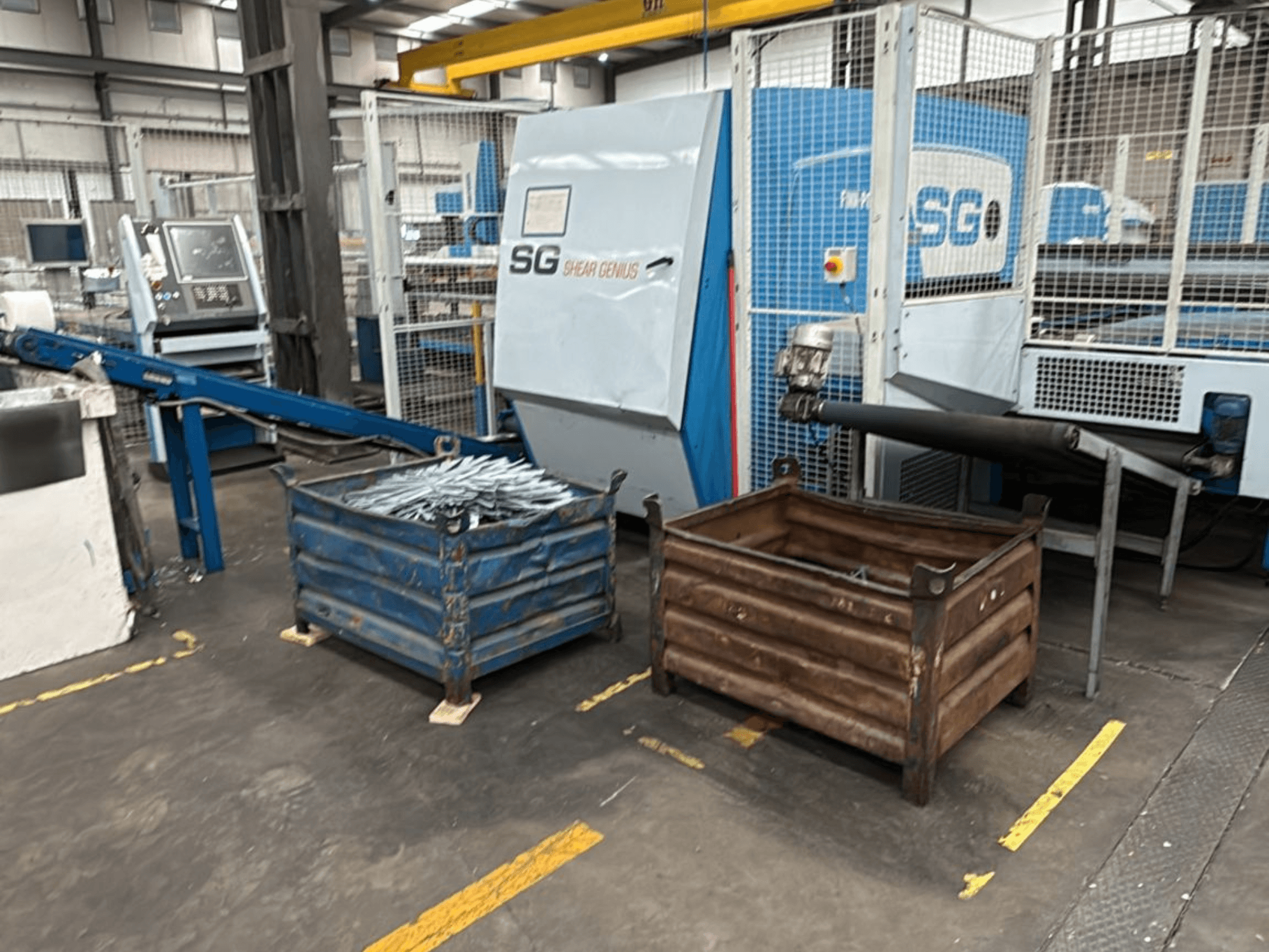 Finn-Power SG6 12.61 pons- en buigmachine, vooraanzicht met metalen containers ernaast in een werkplaats.