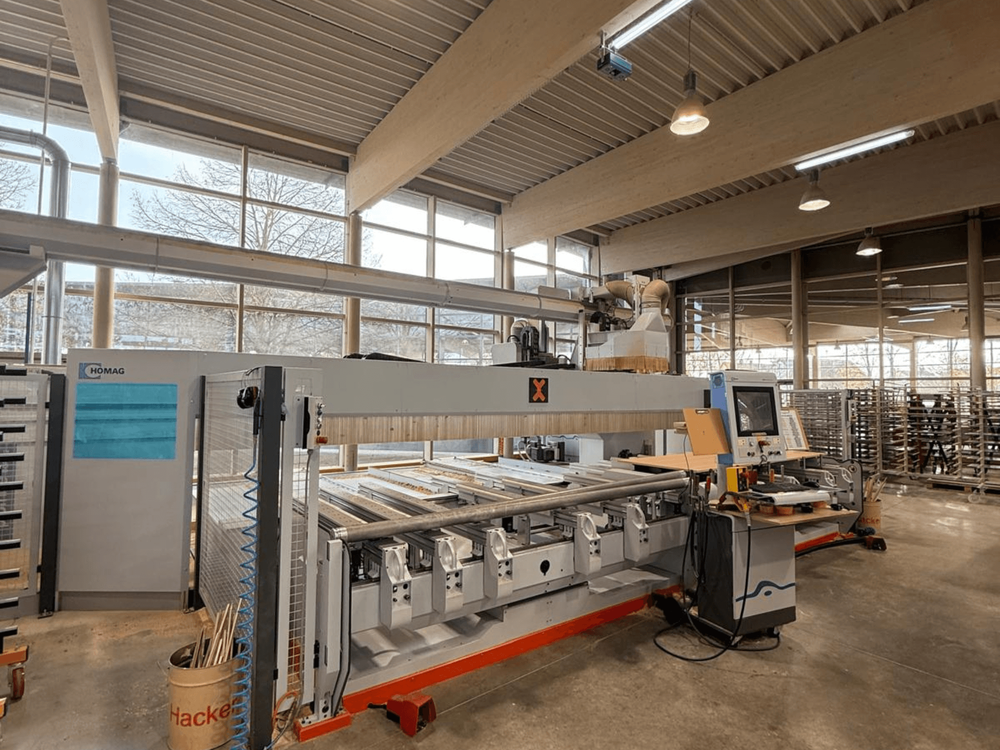 HOMAG CNC machine in een werkplaats, vooraanzicht, met een bedieningspaneel en meerdere sleuven voor precisie houtbewerking.