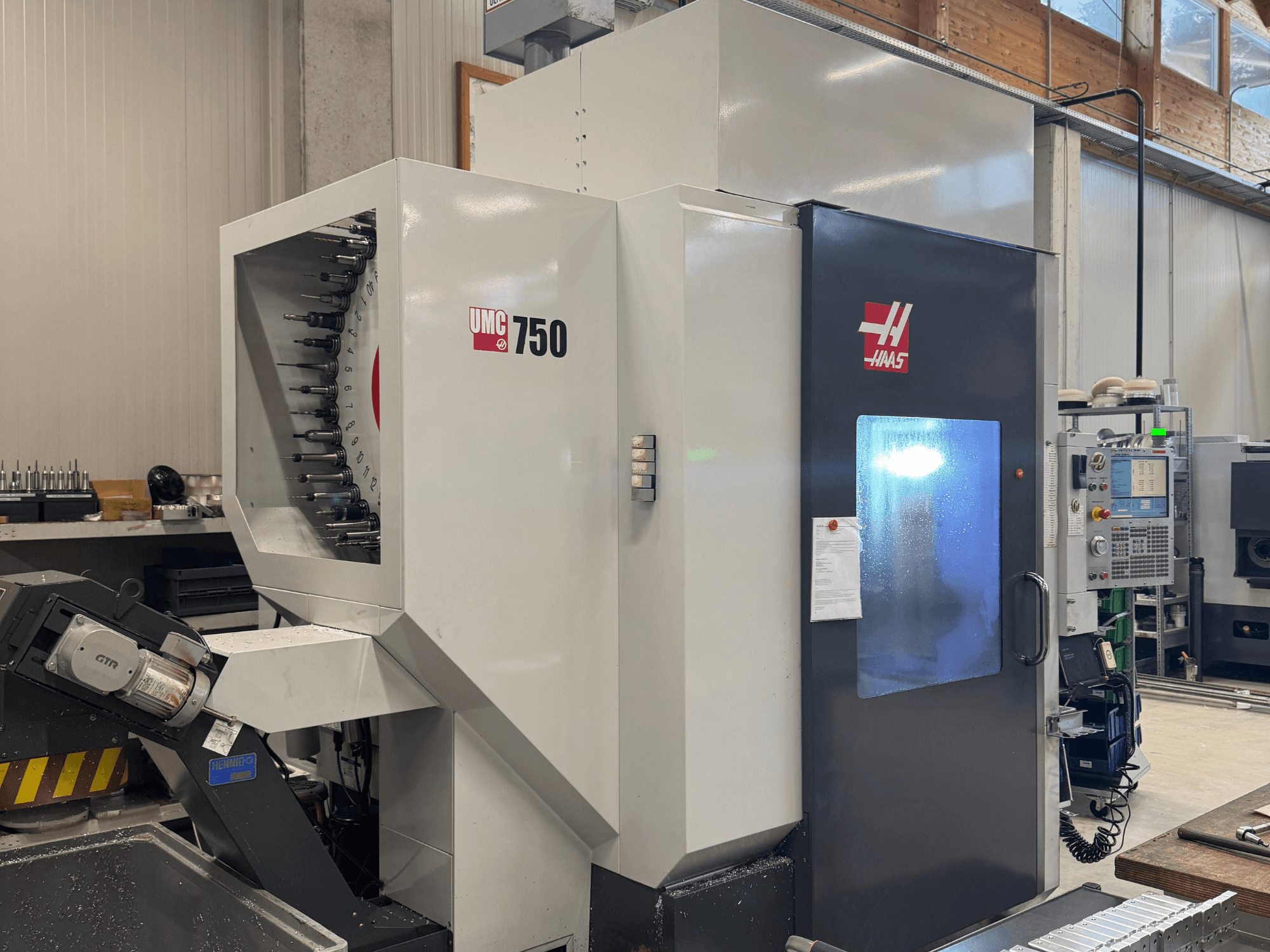 Het Haas UMC 750 bewerkingscentrum, vooraanzicht, toont de gereedschaphouder en het bedieningspaneel in een werkplaats.