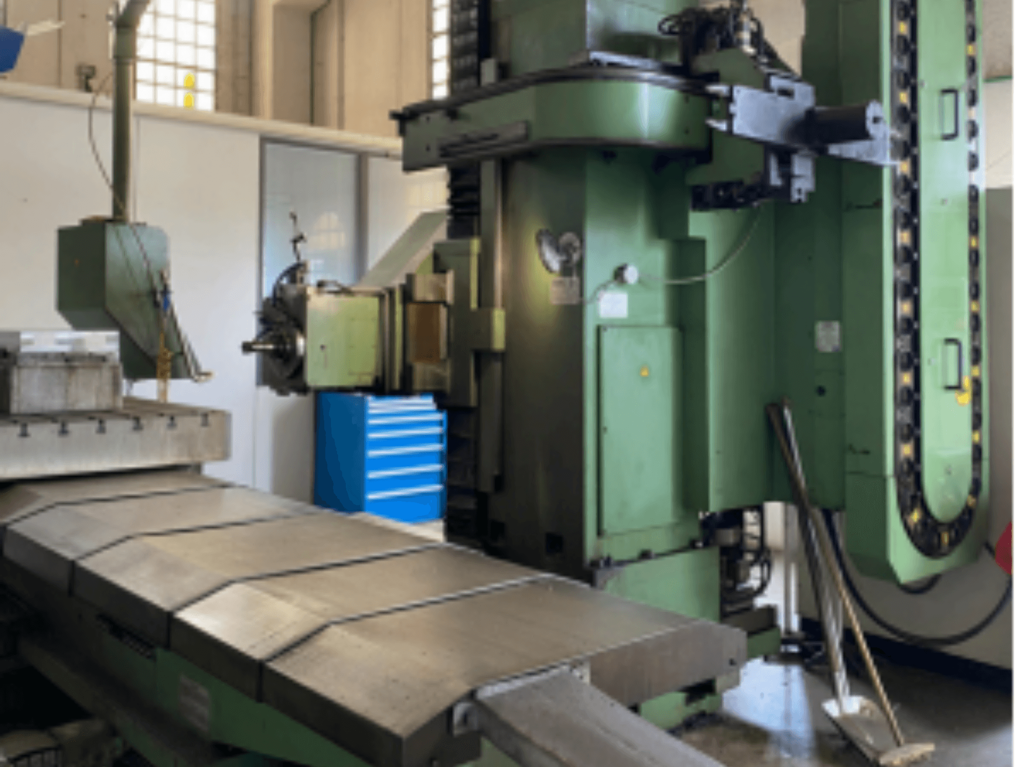 Vooraanzicht van de DEBER BTM 5A bedfreesmachine, met een grote metalen tafel en bedieningspaneel met groene afwerking.