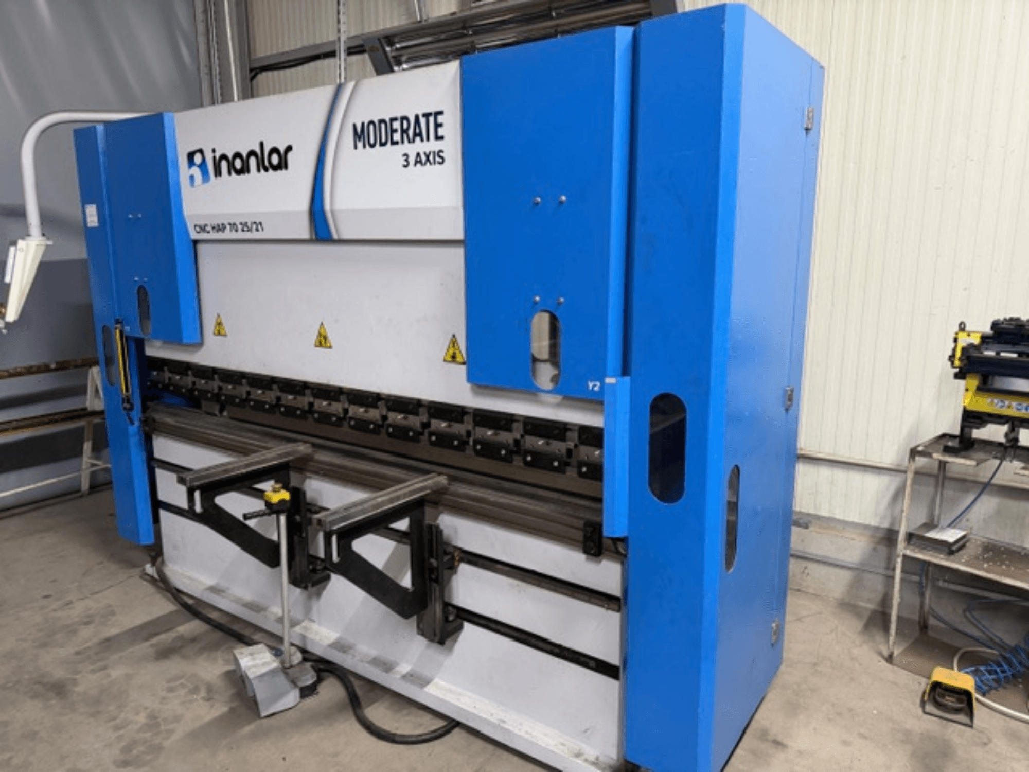 Inanlar Moderate 3-assige CNC machine in blauw, vooraanzicht, met bedieningshendels en veiligheidslabels zichtbaar op de behuizing.