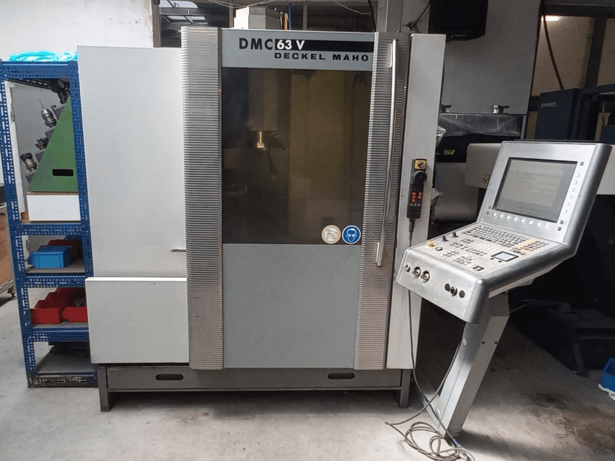 Vooraanzicht van het verticale bewerkingscentrum DMG DECKEL MAHO DMC 63V met bedieningspaneel en zichtbaar werkgebied.