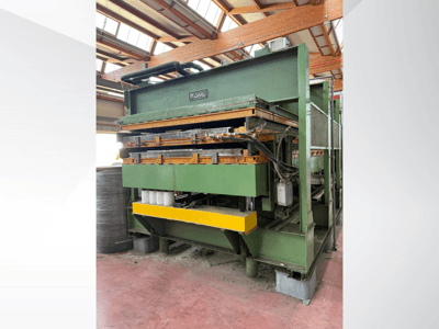Hydraulische pers van Manni, zijaanzicht, met groen metalen huis, gele basis en meerdere hydraulische leidingen zichtbaar.