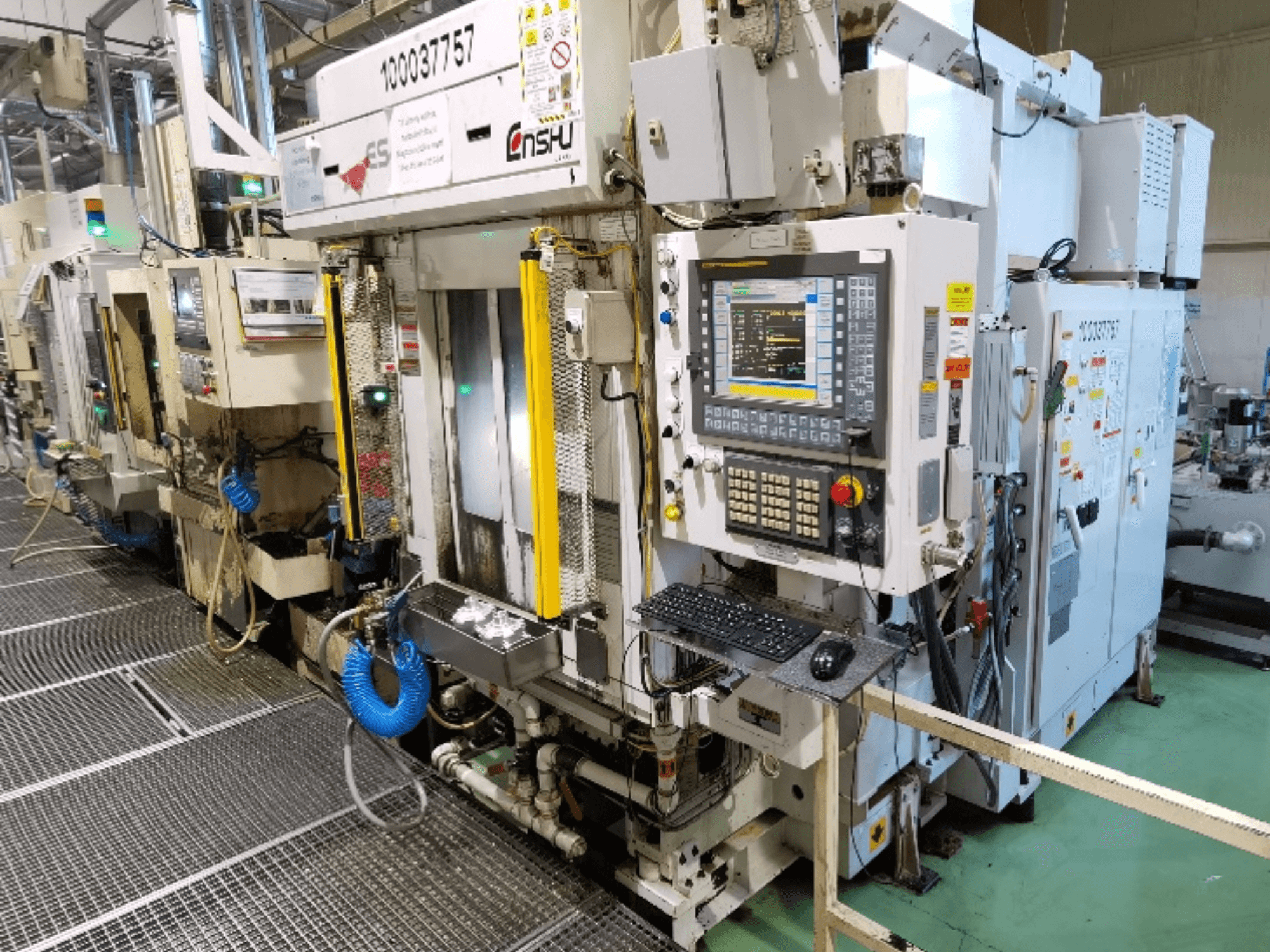 Alternatieve tekst: Vooraanzicht van het verticale bewerkingscentrum Enshu ES400, met bedieningspaneel, toetsenbord en gedetailleerde machineonderdelen.