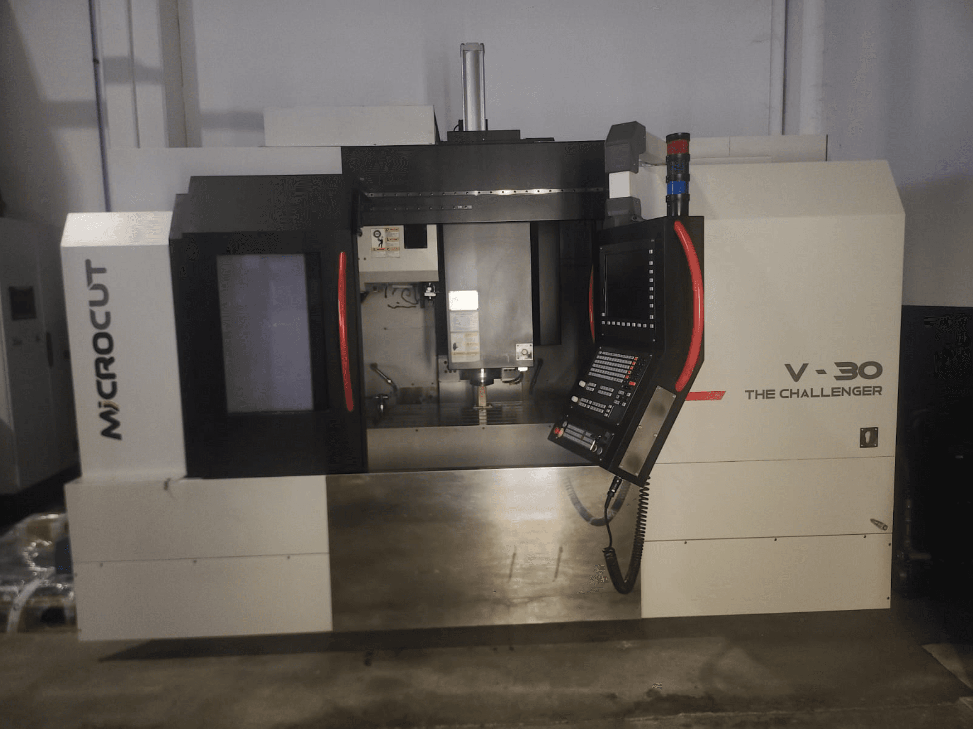 Microcut V-30 De Challenger CNC machine, vooraanzicht, met bedieningspaneel, snijgedeelte en industriële ontwerpelementen.