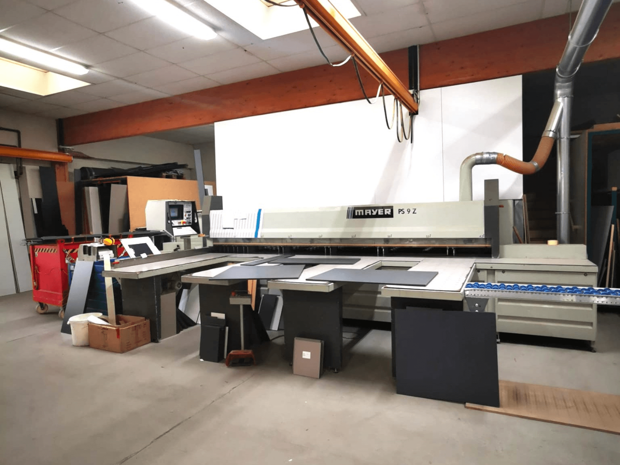 MAYER PS9 Z snijmachine in een werkplaats, vooraanzicht, met verschillende materialen en een transportsysteem zichtbaar.