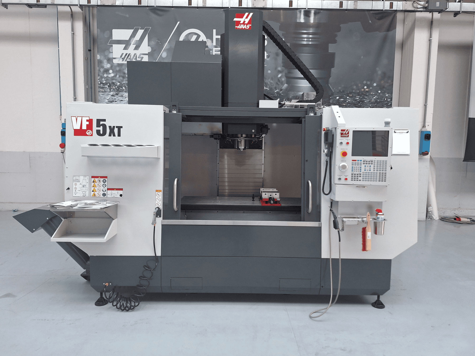 HAAS VF-5/50XT verticaal bewerkingscentrum, vooraanzicht, met het bedieningspaneel, het spilgedeelte en de gereedschapopslag.