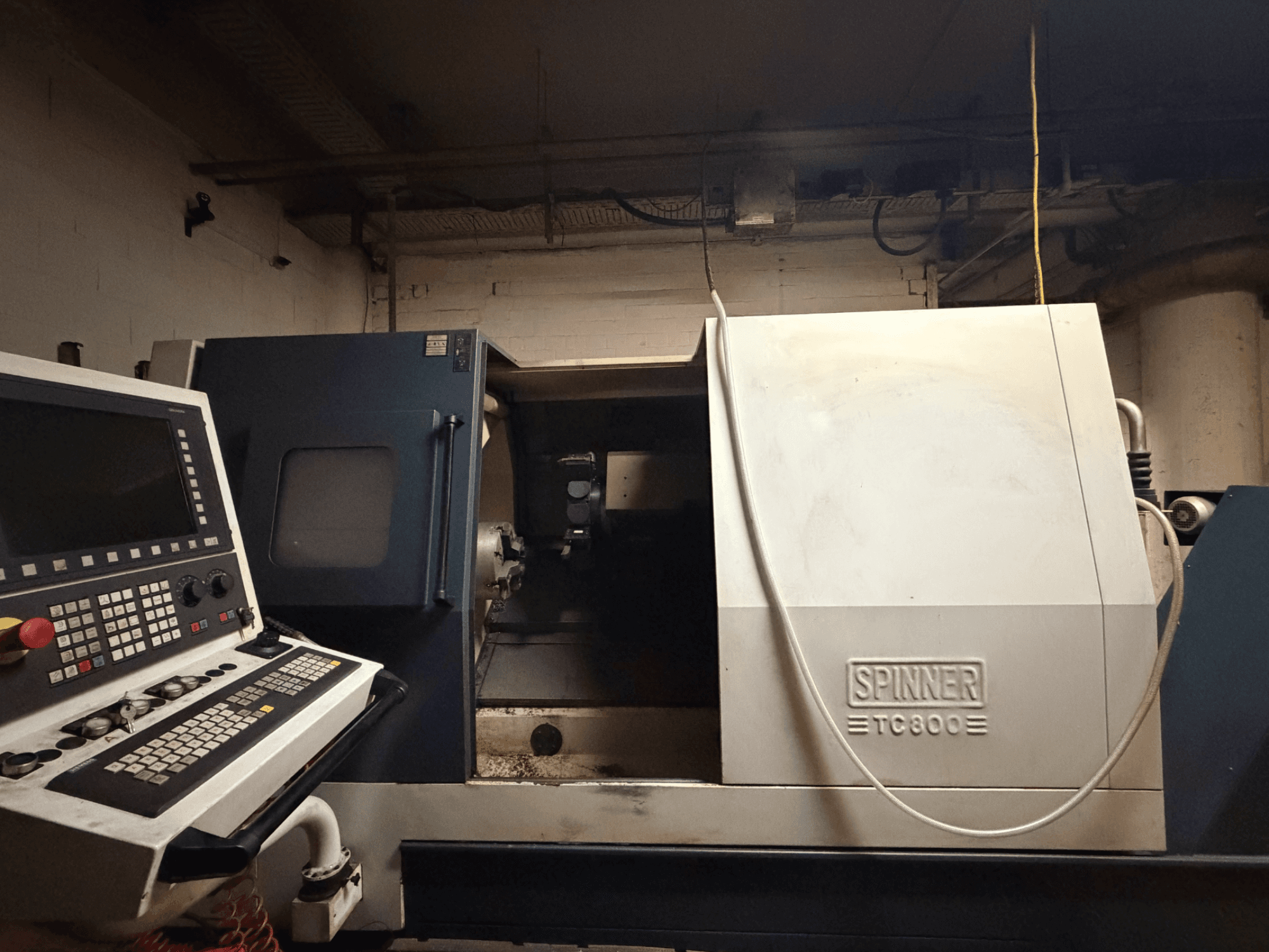 Horizontale draaimachine SPINNER TC800, vooraanzicht met bedieningspaneel zichtbaar en machine-interieur licht zichtbaar.