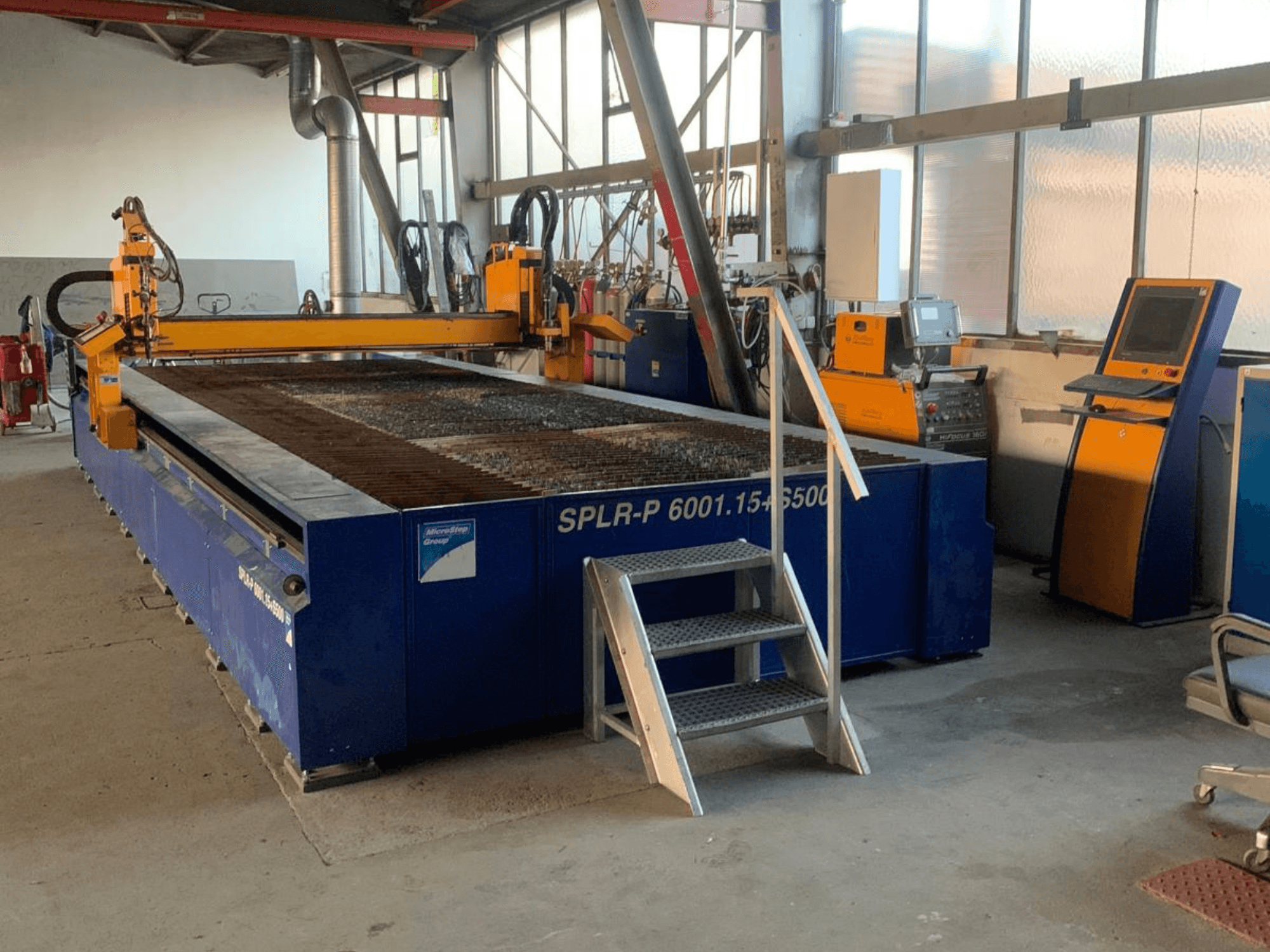 De MicroStep SPLR-P-plasmasnijmachine, gezien vanuit de werkplaats, met een metalen snijtafel en een bedieningspaneel.