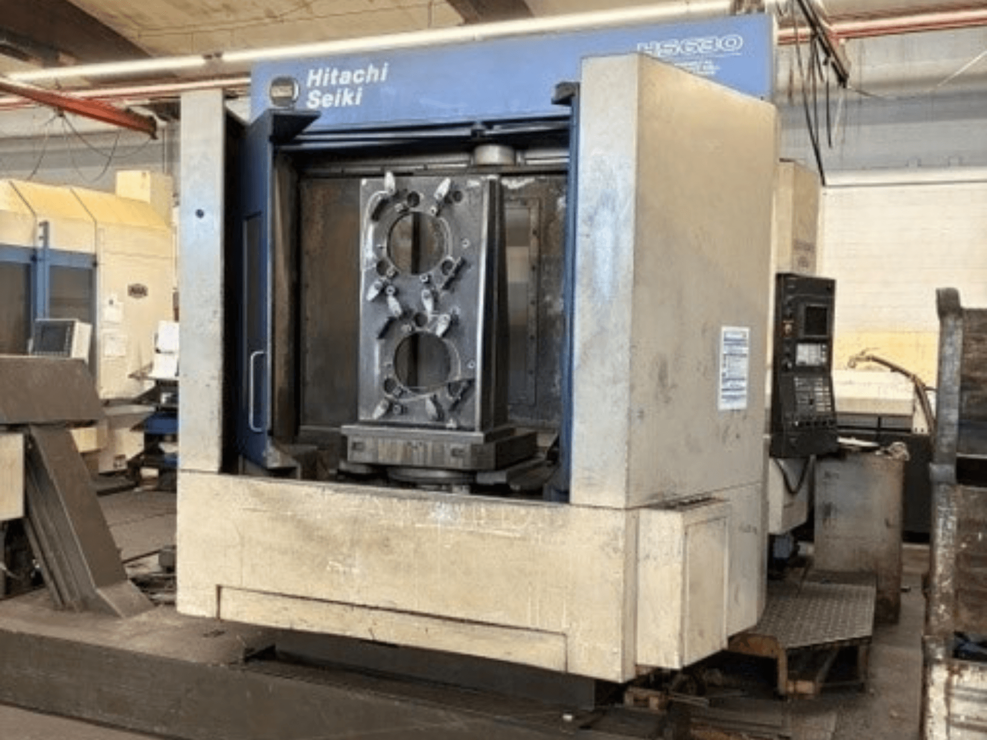 Hitachi Seiki HS630 horizontaal bewerkingscentrum, vooraanzicht met een werkstuk en het bedieningspaneel.