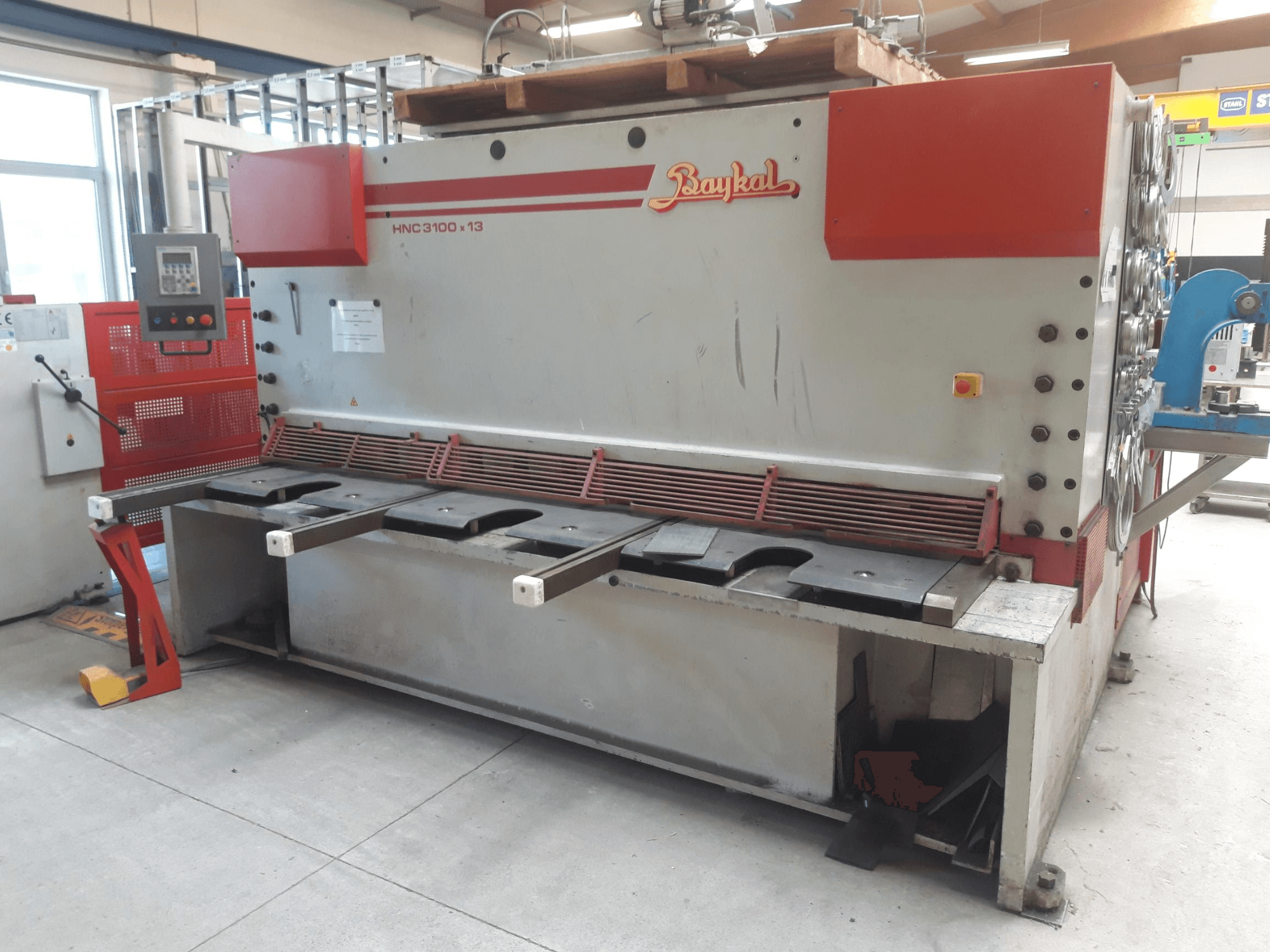 Baykal HNC 3100x13 CNC-schaar, vooraanzicht, met bedieningspaneel, snijgebied voor metaal en ruimte voor afvalopvang.