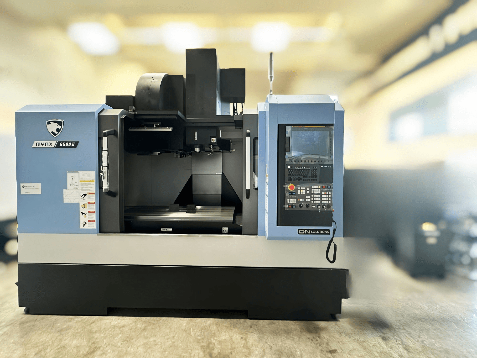 Verticaal bewerkingscentrum DN SOLUTIONS MYNX 6500 II, vooraanzicht met het bedieningspaneel en het werkgebied.