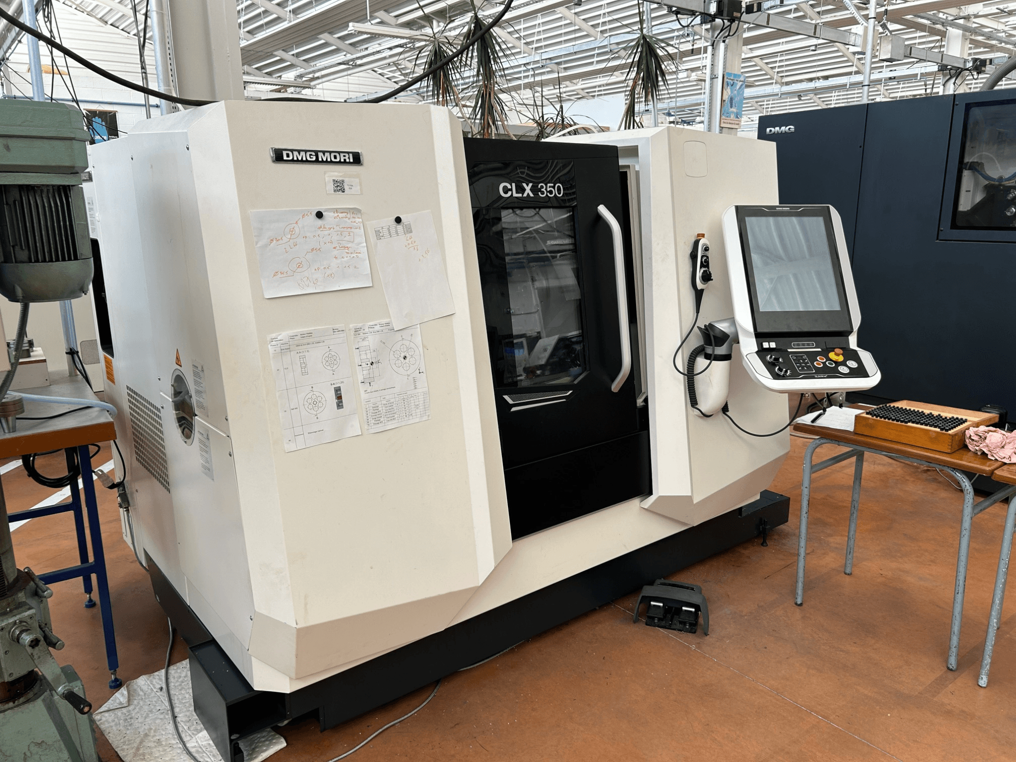 DMG MORI CLX 350 V4 horizontale draaibank, vooraanzicht met bedieningspaneel en bijgevoegde technische documentatie.