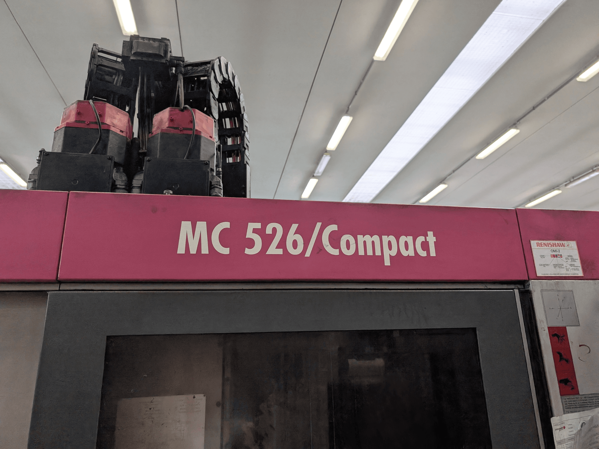 Roze MC 526/Compact machine met dubbele motoren en kabels, van bovenaf gezien. Inclusief Renishaw label op zijkant.