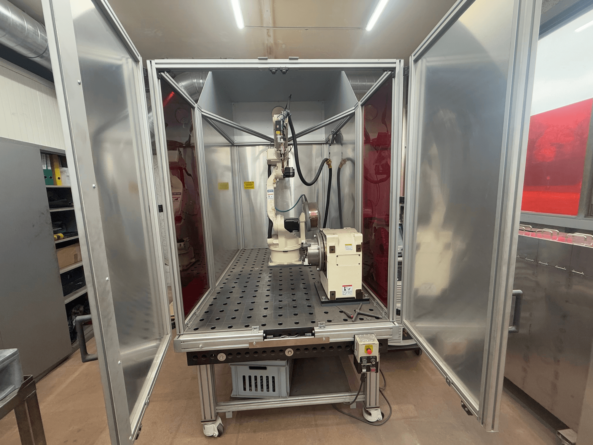 Lasrobot OTC Daihen EASY ARC V02.04 in een metalen behuizing, gezien vanaf de voorkant, met de scharnierarm en het bedieningspaneel.