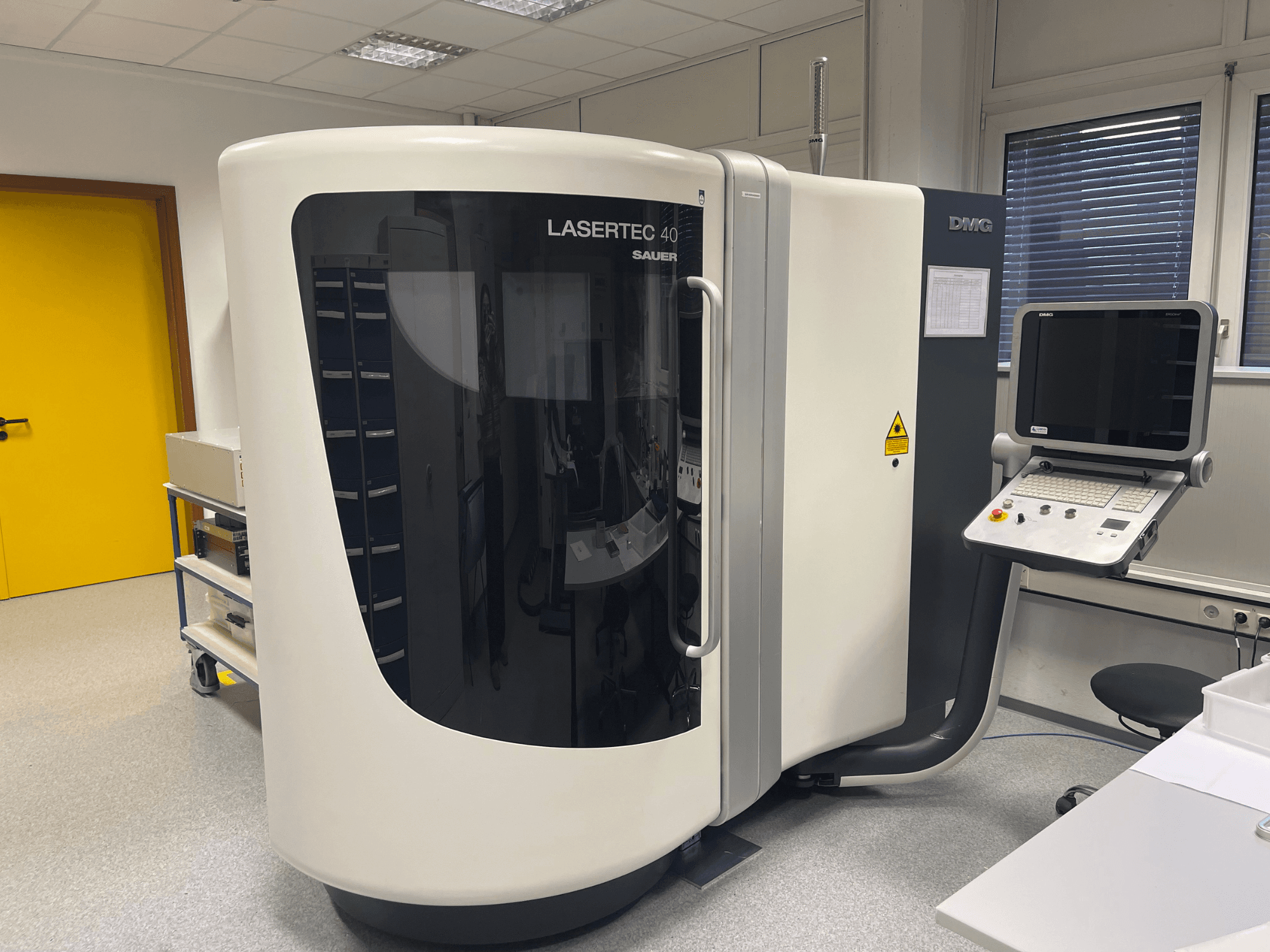 Witte LASERTEC 40 freesmachine van DMG MORI, vooraanzicht, met bedieningspaneel en ergonomisch ontwerp in een goed verlichte ruimte.