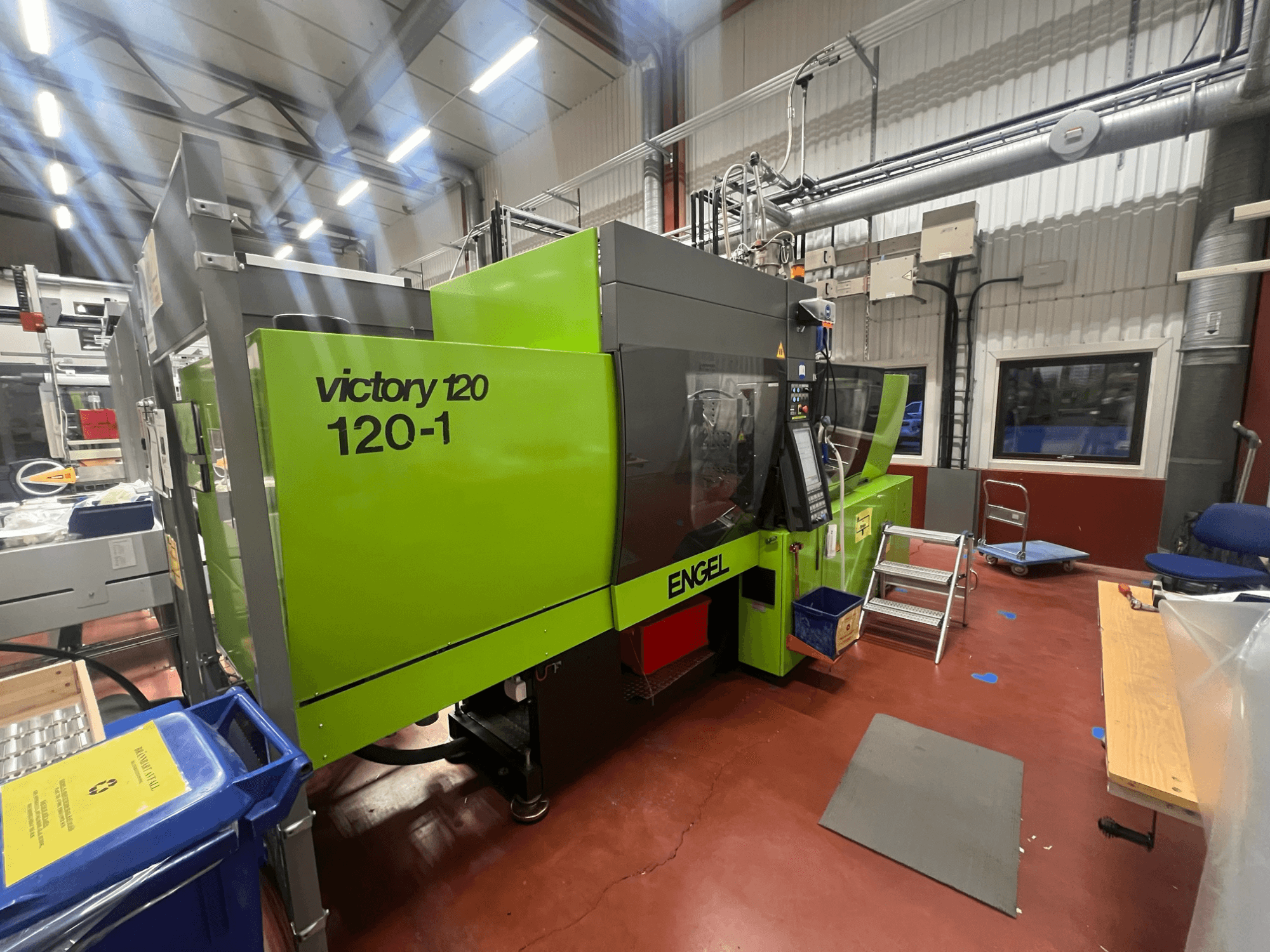 Groene ENGEL Victory 120-1 spuitgietmachine, vooraanzicht, met bedieningspaneel en stappen, in een industriële omgeving.