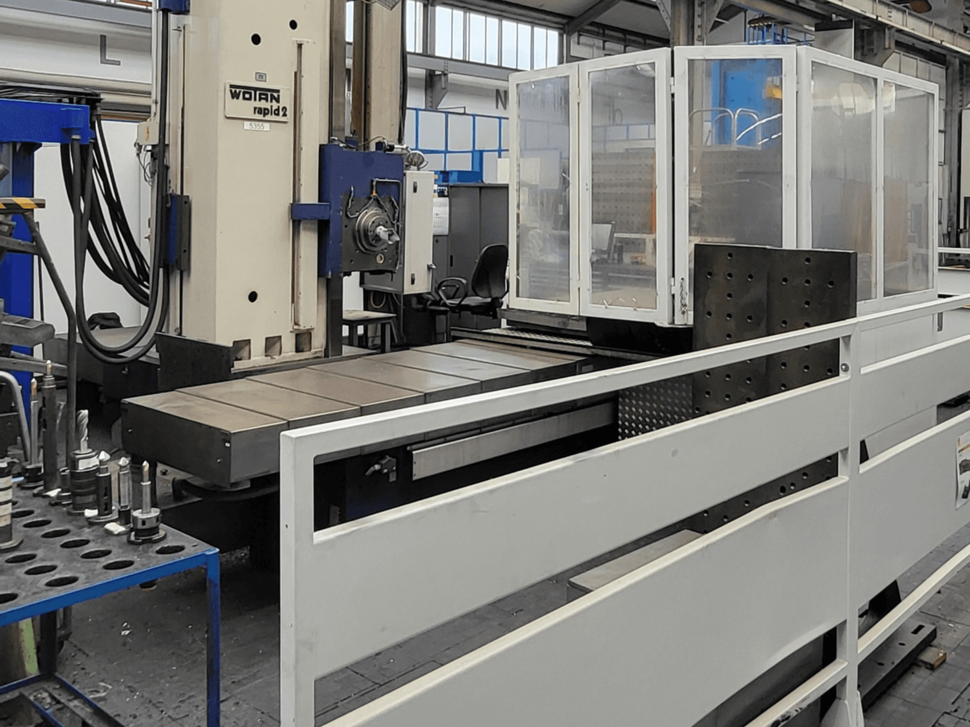 Het horizontale bewerkingscentrum WOTAN Rapid 2R/6-1500/2, afgebeeld in vooraanzicht, met een grote werktafel en een beschermende behuizing.