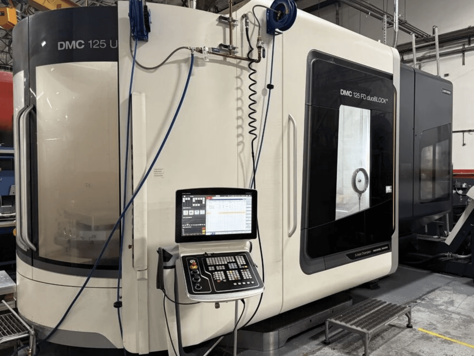Universeel bewerkingscentrum DMG MORI DMC 125 U duoBLOCK, vooraanzicht met bedieningspaneel en reflecterende oppervlakken.