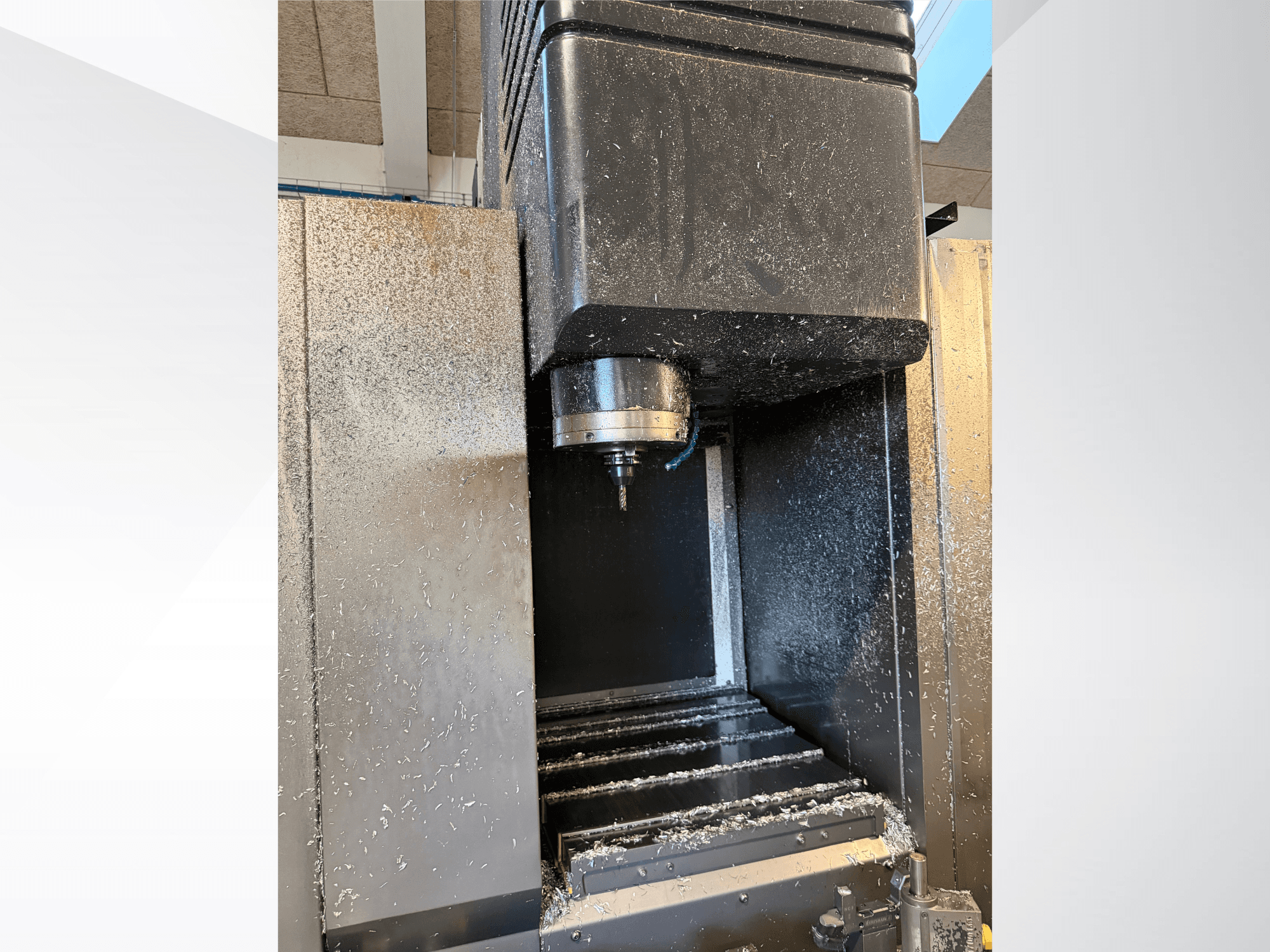 Mazak VTC 300C II verticaal bewerkingscentrum, vooraanzicht, met zicht op de spil en de spanen die bij het bewerkingsproces vrijkomen.